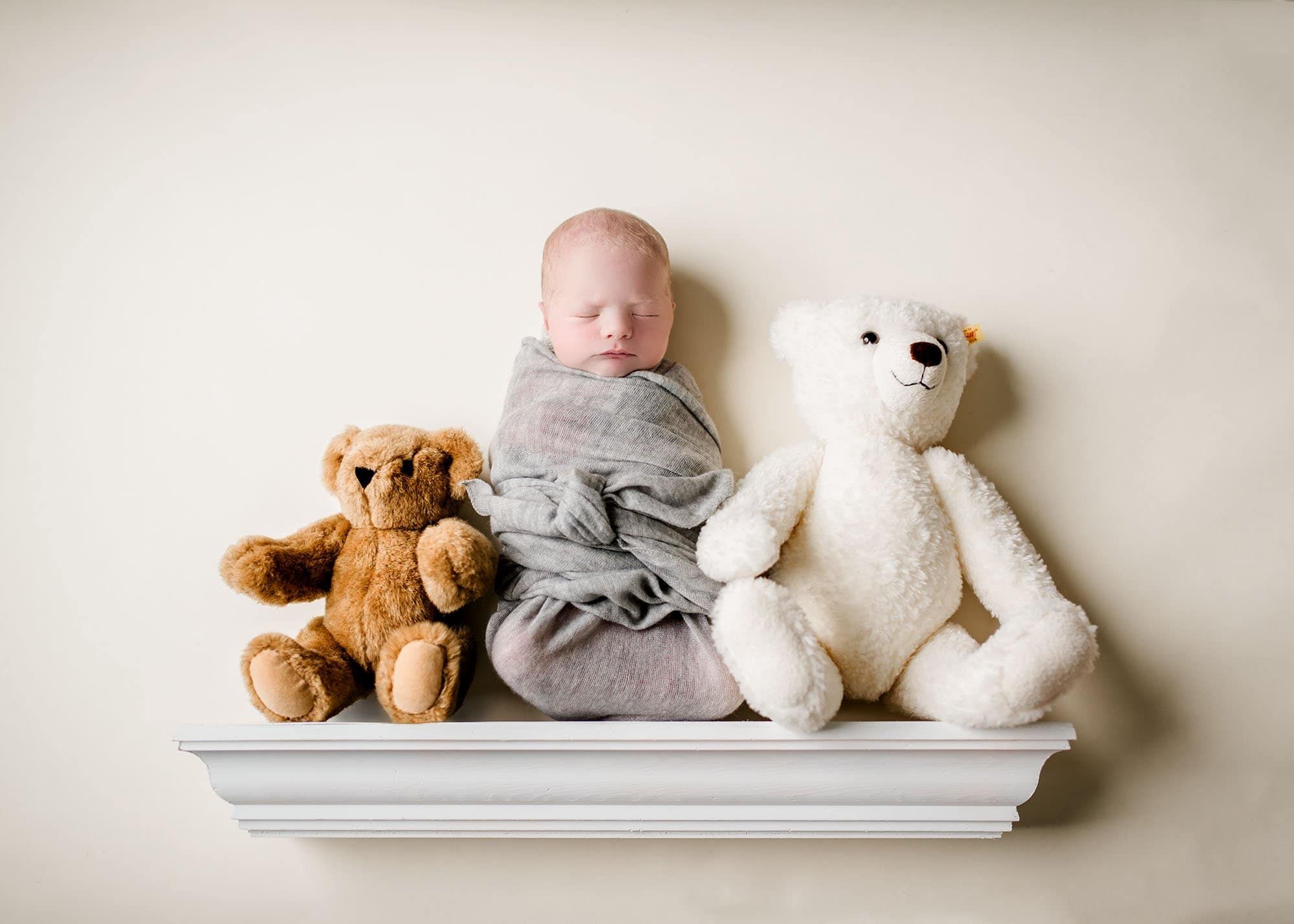 Newborn baby boy sitting on a shelf with his teddy bear collection Glastonbury CT Newborn Photographer One Big Happy Photo www.onebighappyphoto.com/newborns