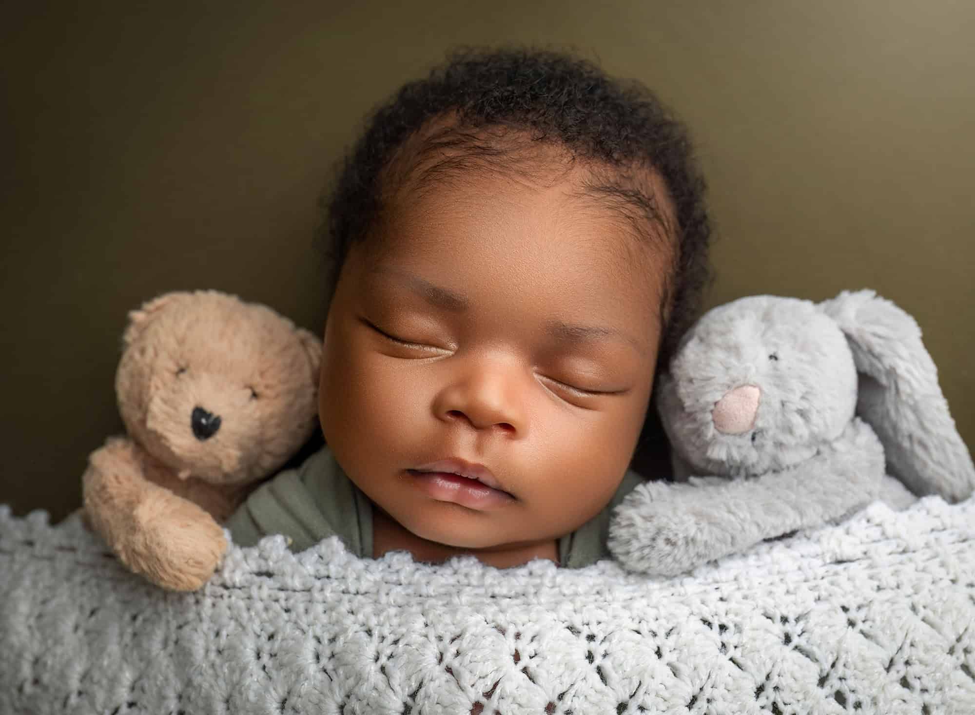 peaceful newborn session Glastonbury newborn baby sleeping with a teddy bear and bunny rabbit