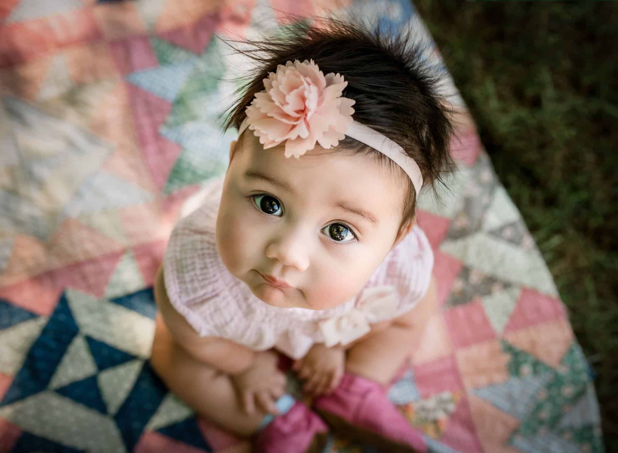 6 month old baby girl looking up at the camera with big sweet eyes 6 month old baby girl looking up at the camera with big sweet eyes