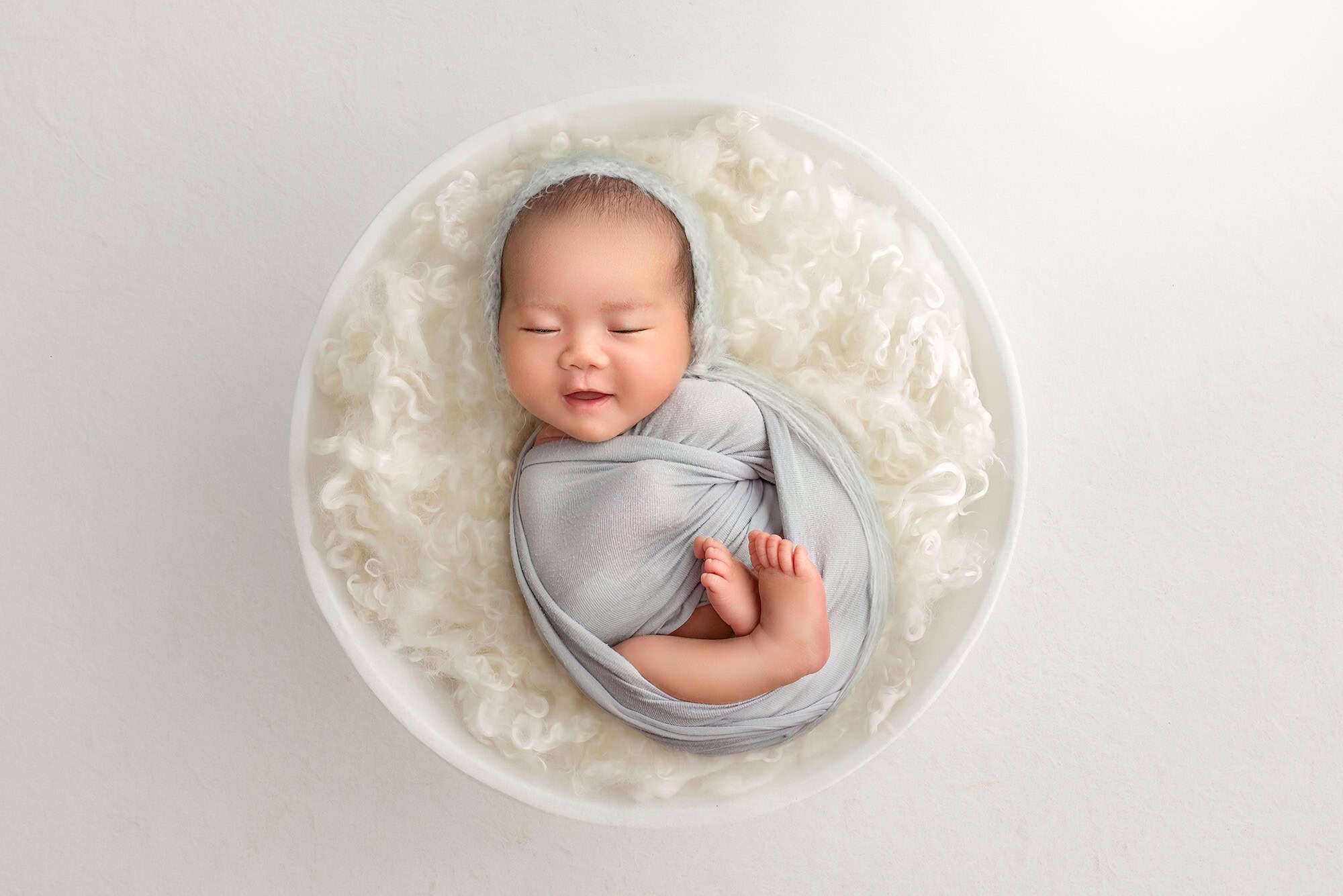 CT newborn photographer newborn baby smiling in a white bowl