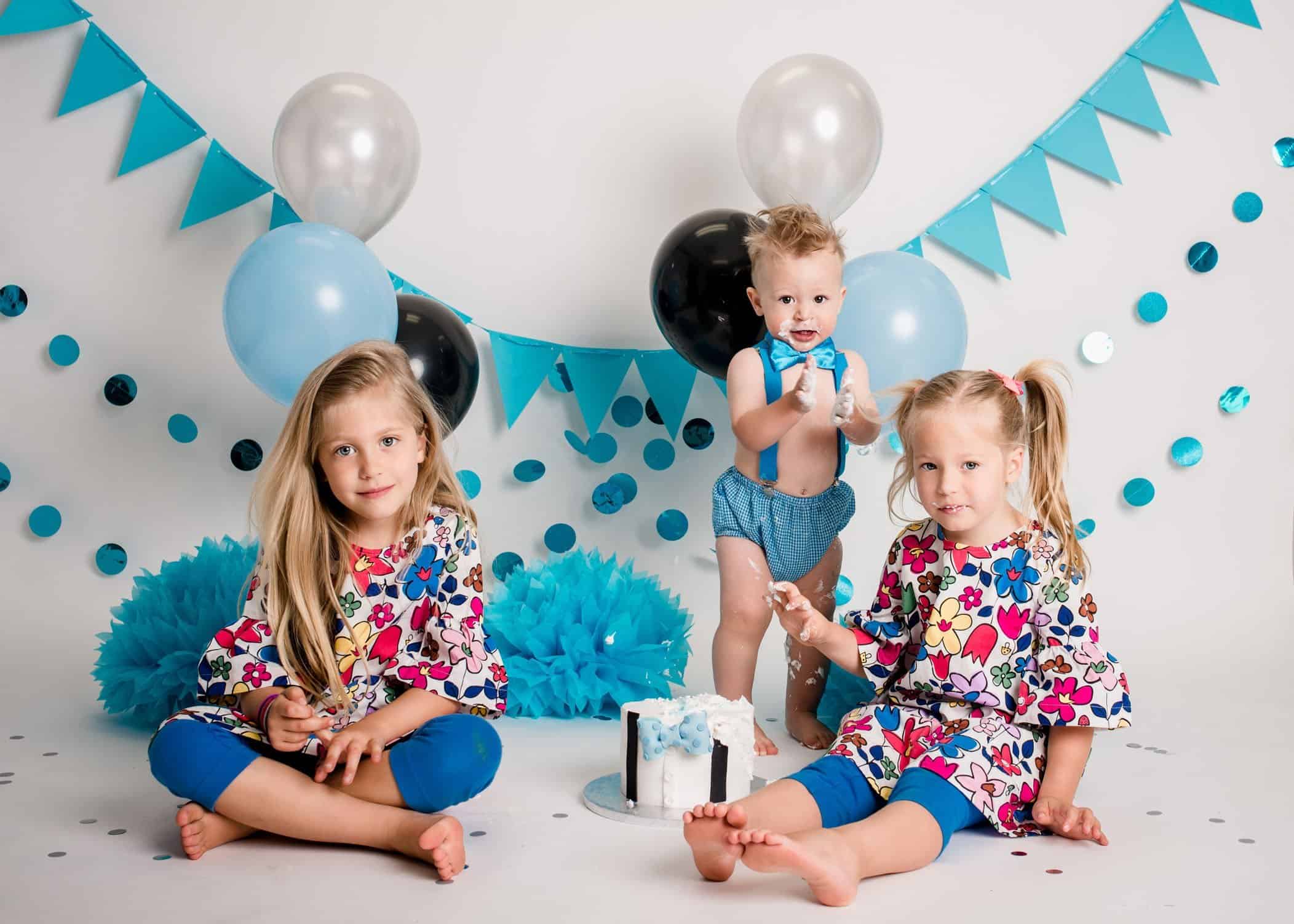 12 month old boy and his two big sisters eat a smash cake