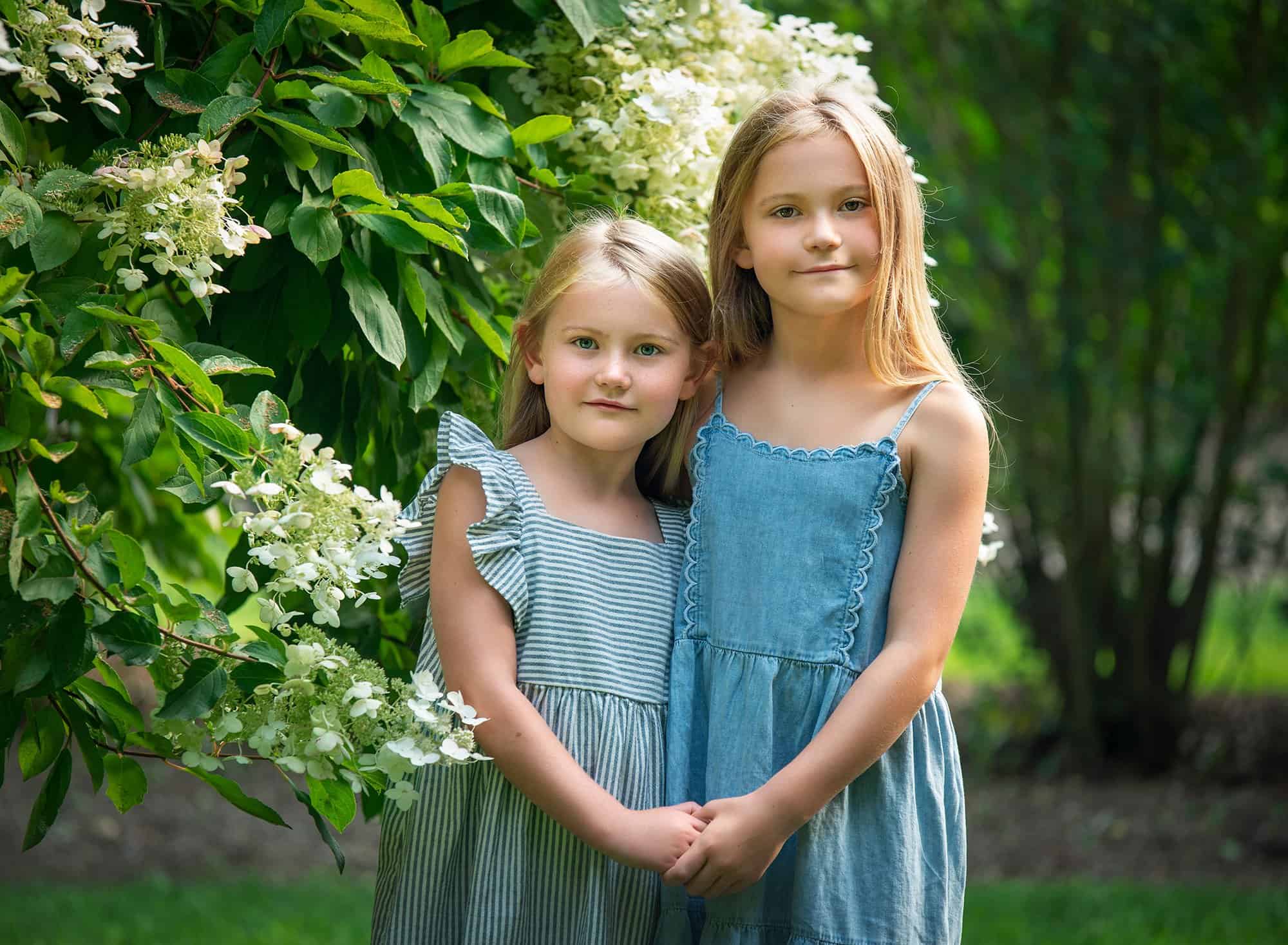 blonde haired sisters posing together in nature