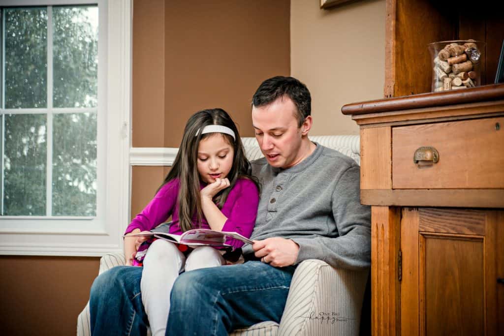 Dad reads a book to his daughter