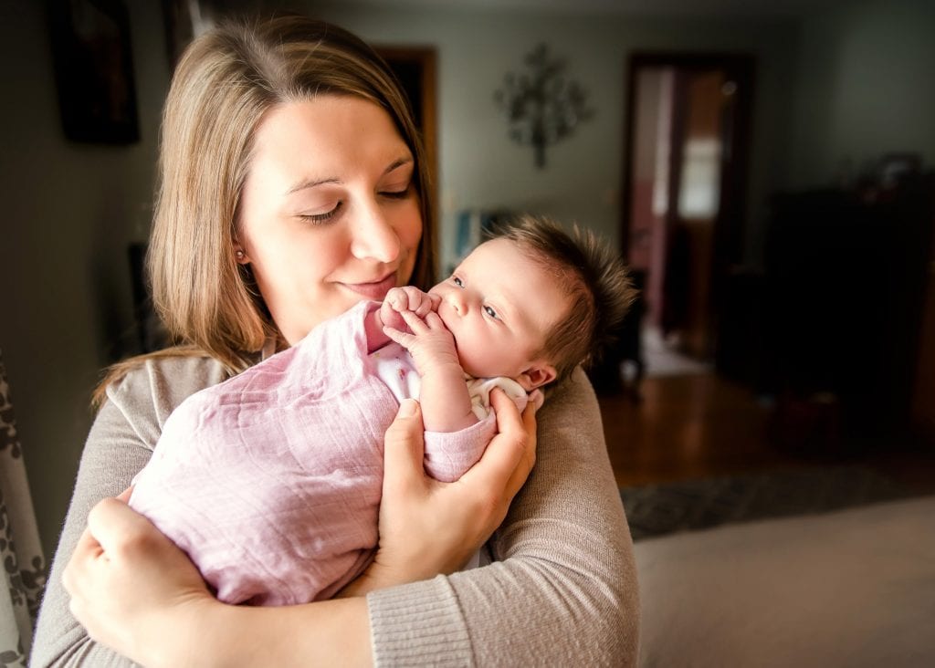 Mom holding newborn girl in her arms