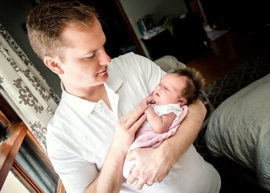 Dad holding newborn baby girl