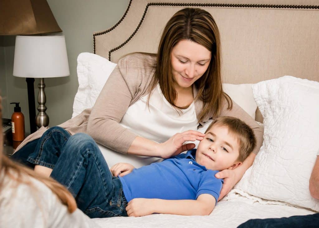 mom and 4 year old son cuddling on bed