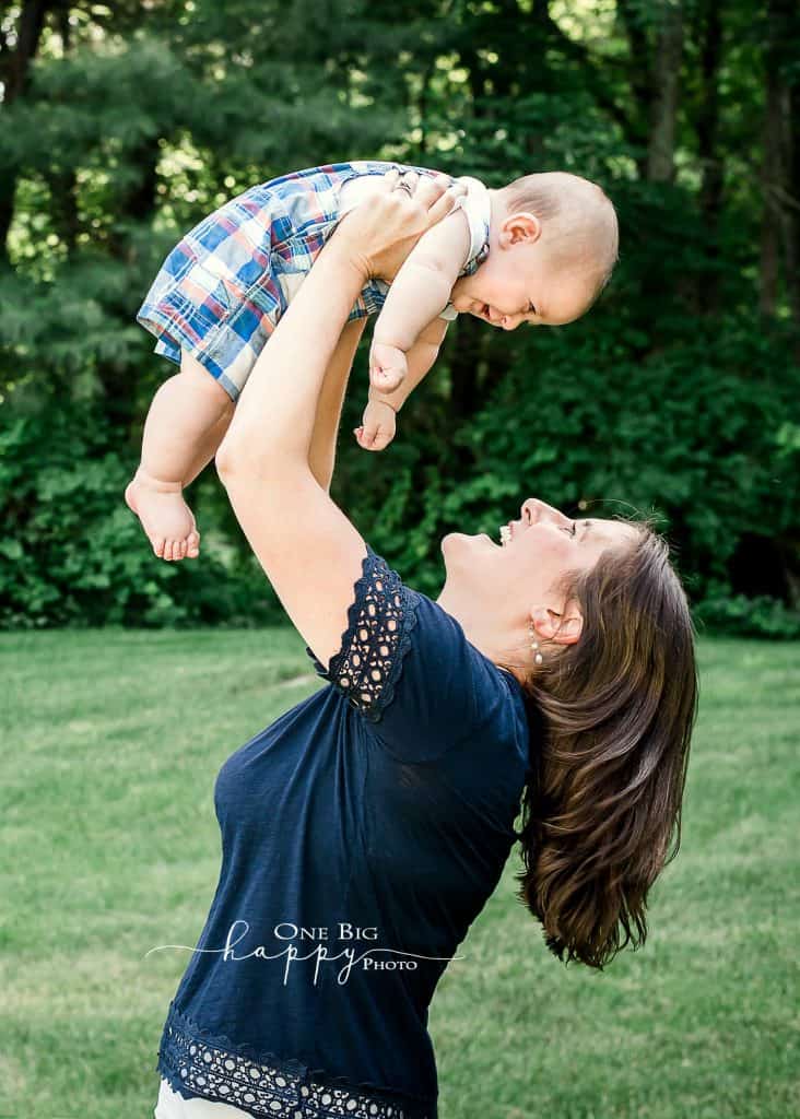 Mom flying 6 month old son outside in summertime