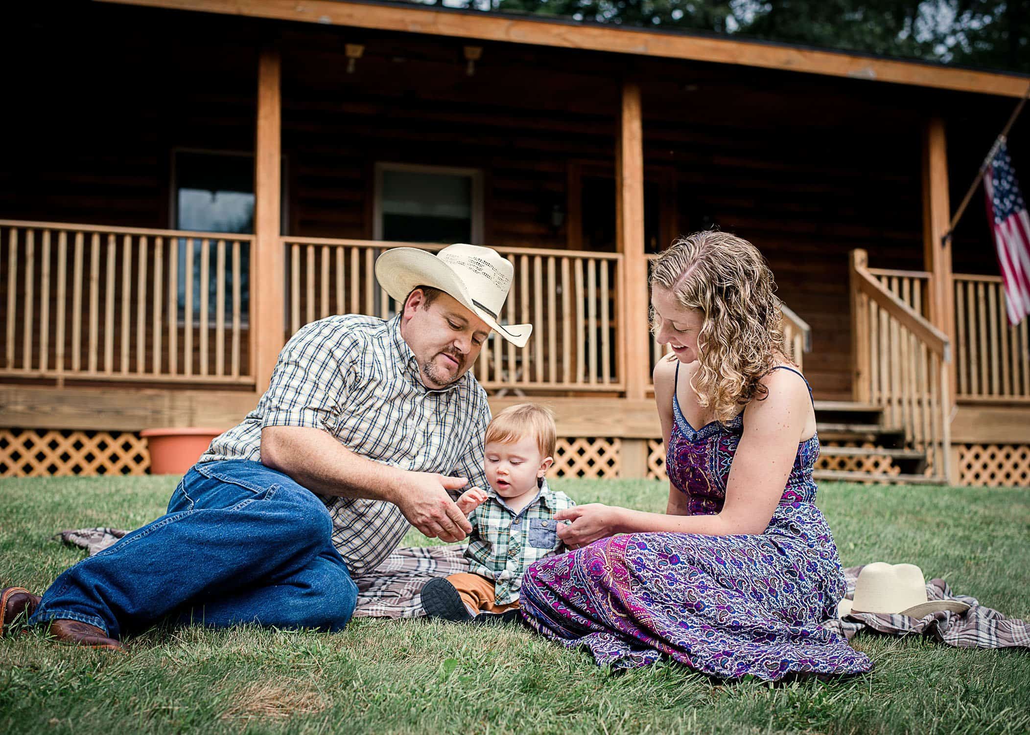 9 mo old baby boy and his mom and dad sitting on the lawn playing together One Big Happy Photo