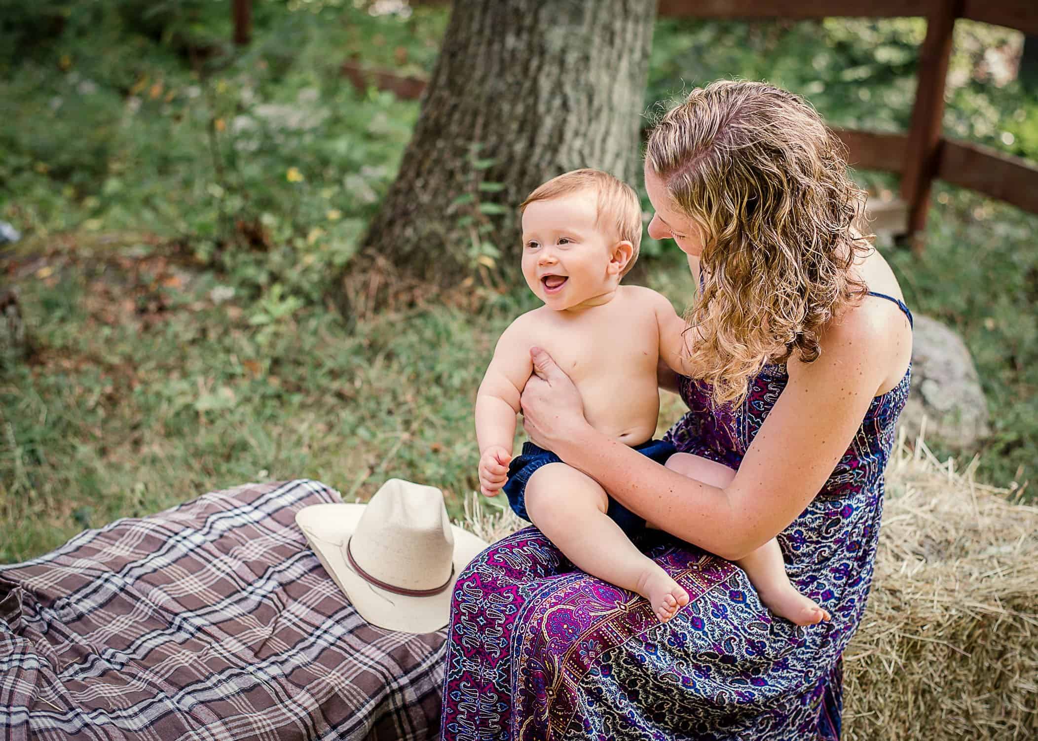 9 mo old baby boy with cowboy hat sitting on Mama's lap outside