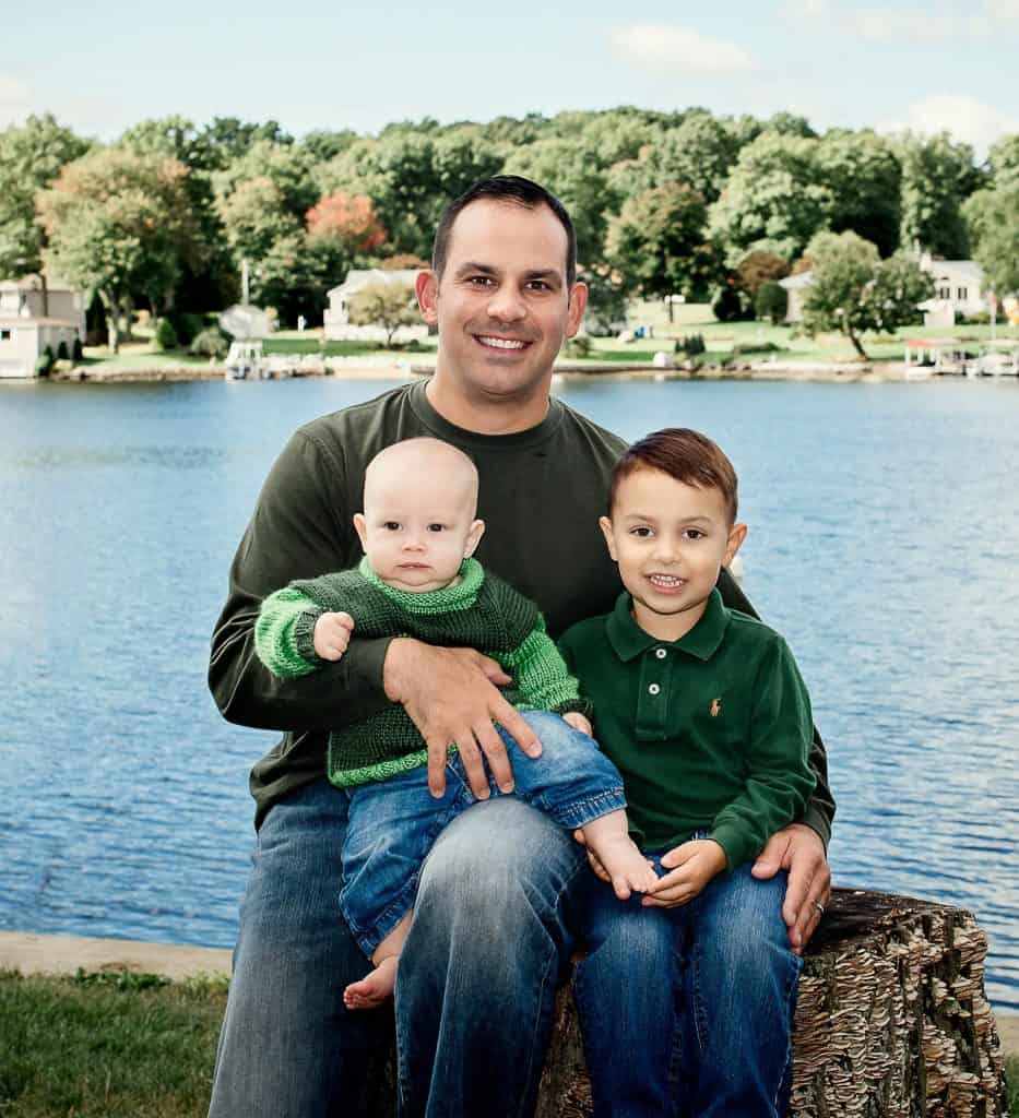 Dad holding his 6 month old son and 3 year old son by the lake One Big Happy Photo