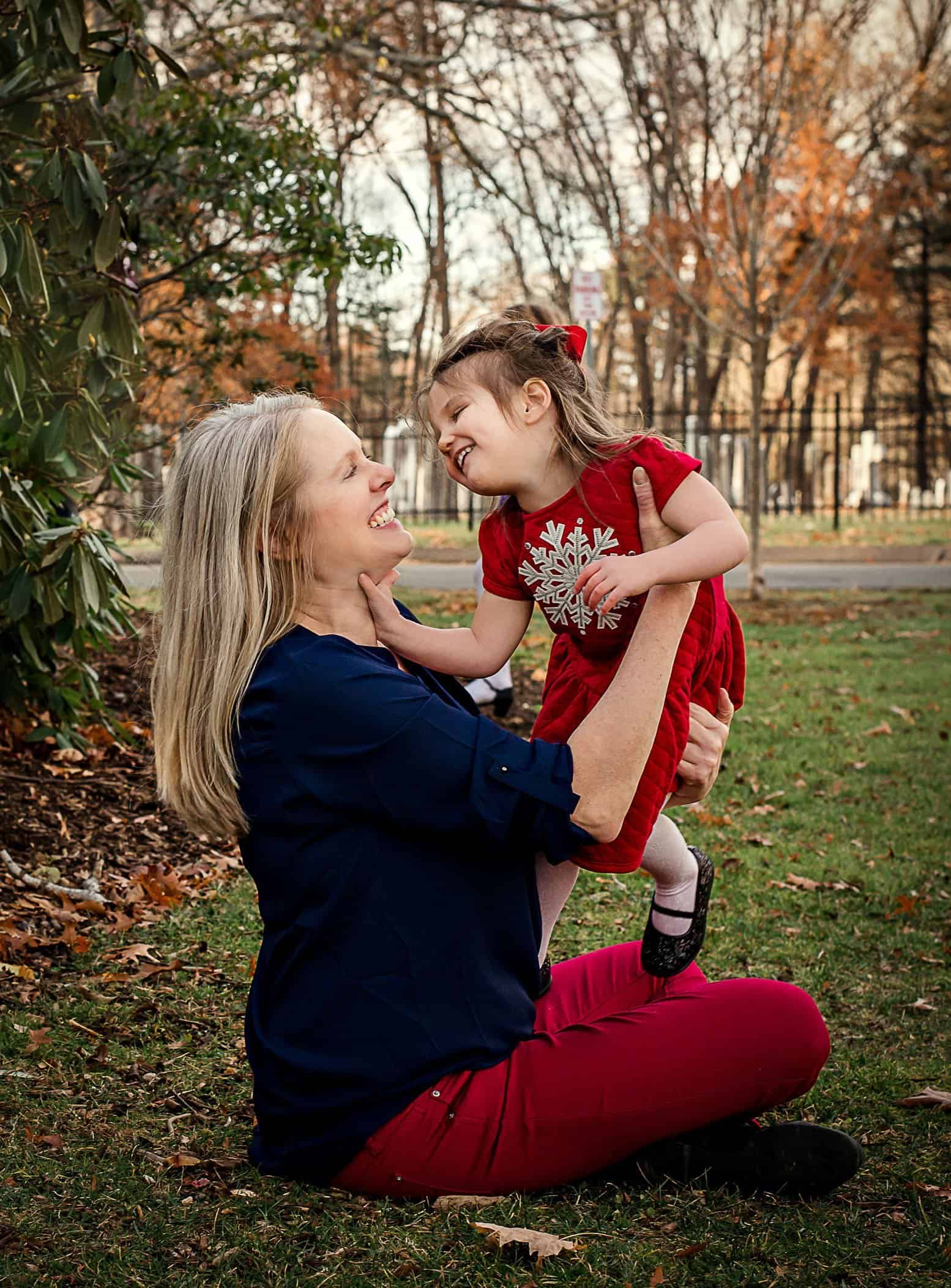 Mom catching a wiley toddler girl and playing in the garden