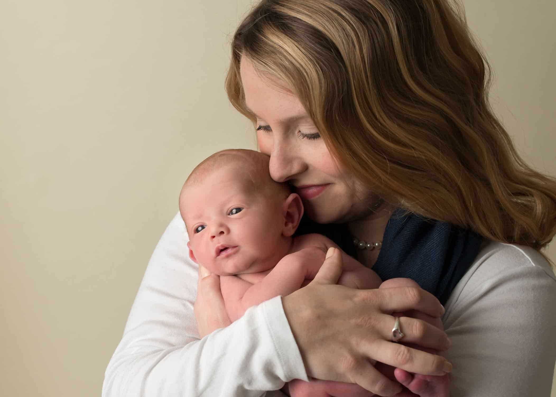 close snuggles between mom and newborn baby One Big Happy Photo