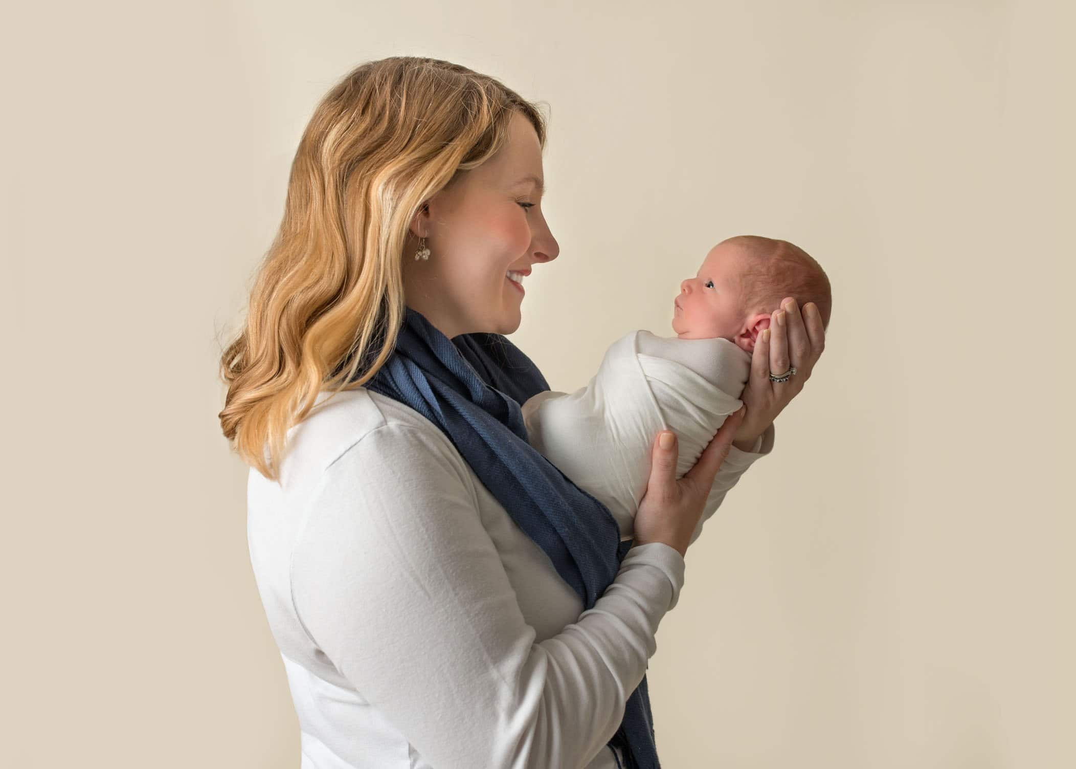 Mom and newborn baby sharing a look One Big Happy Photo