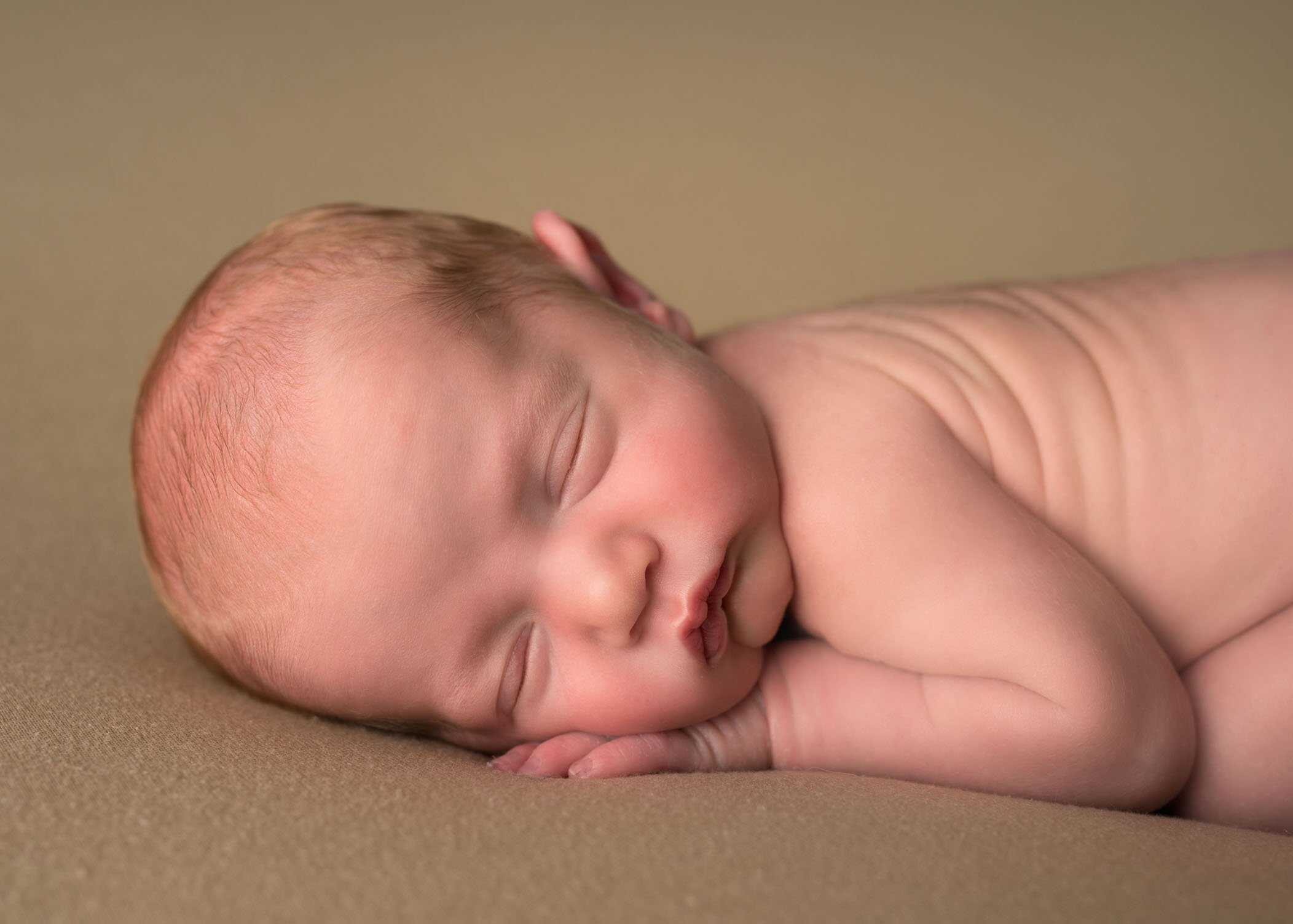 close up of newborn sleeping on his hand One Big Happy Photo