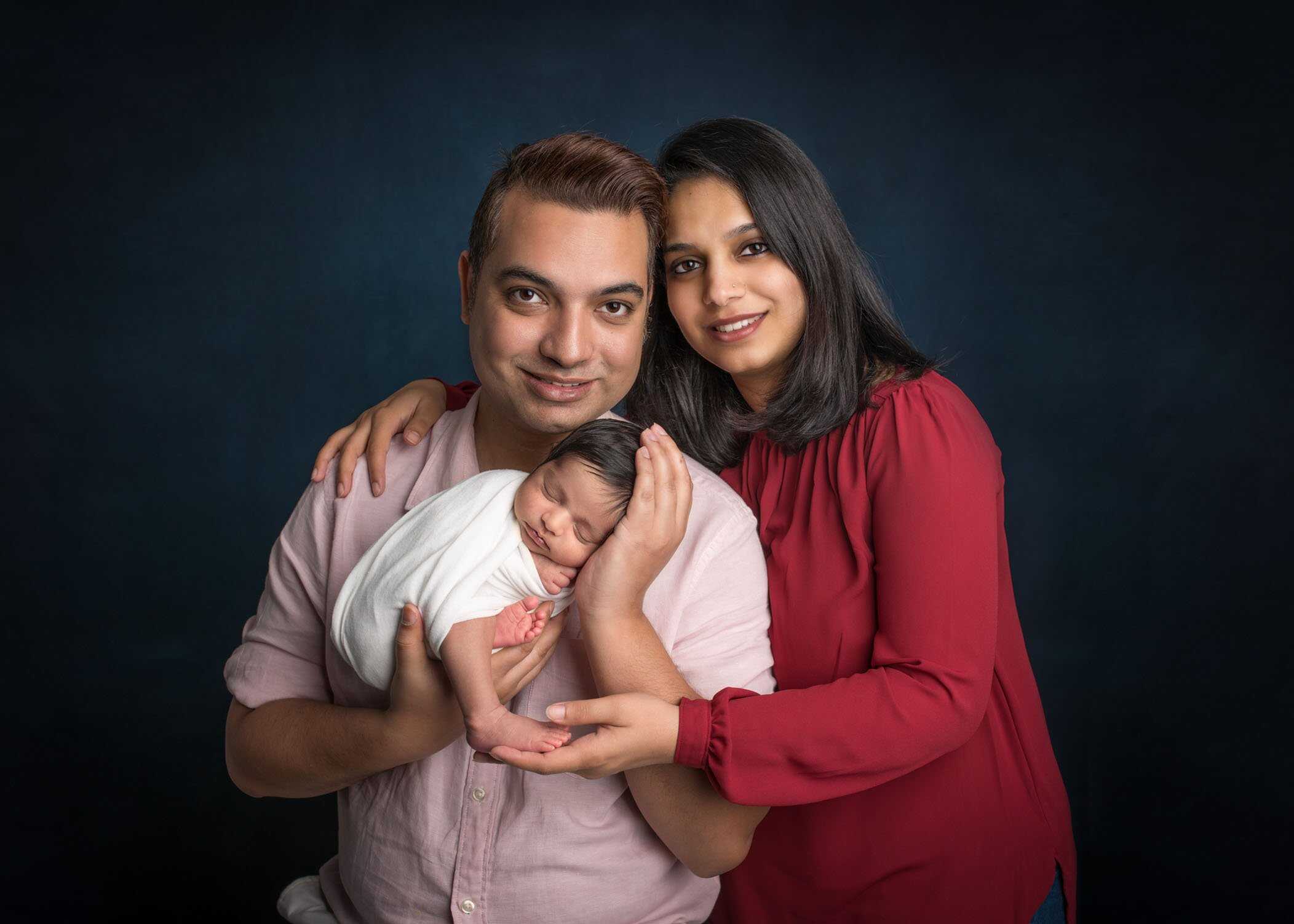 mom dad and newborn daughter portrait