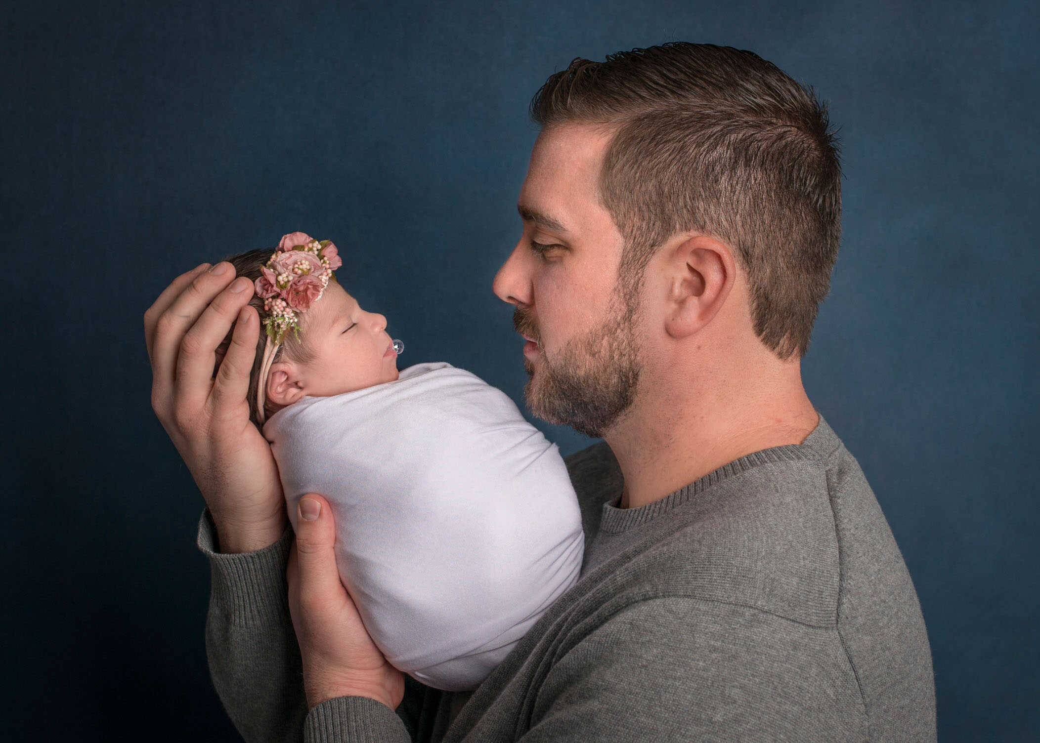 Best CT Newborn Photographer Dad holding newborn baby girl with bubble on her lips