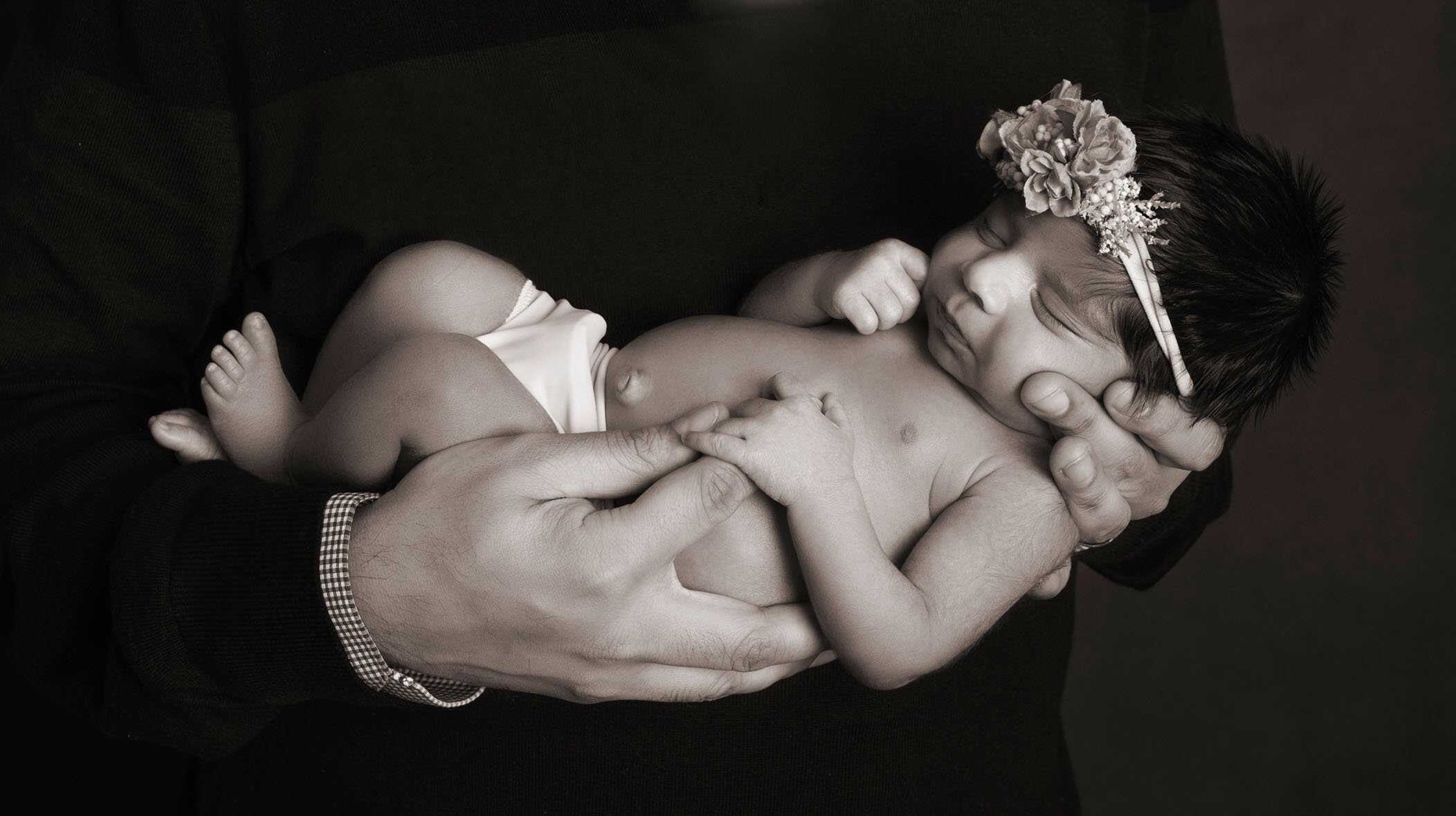 dad holding newborn baby in his hands