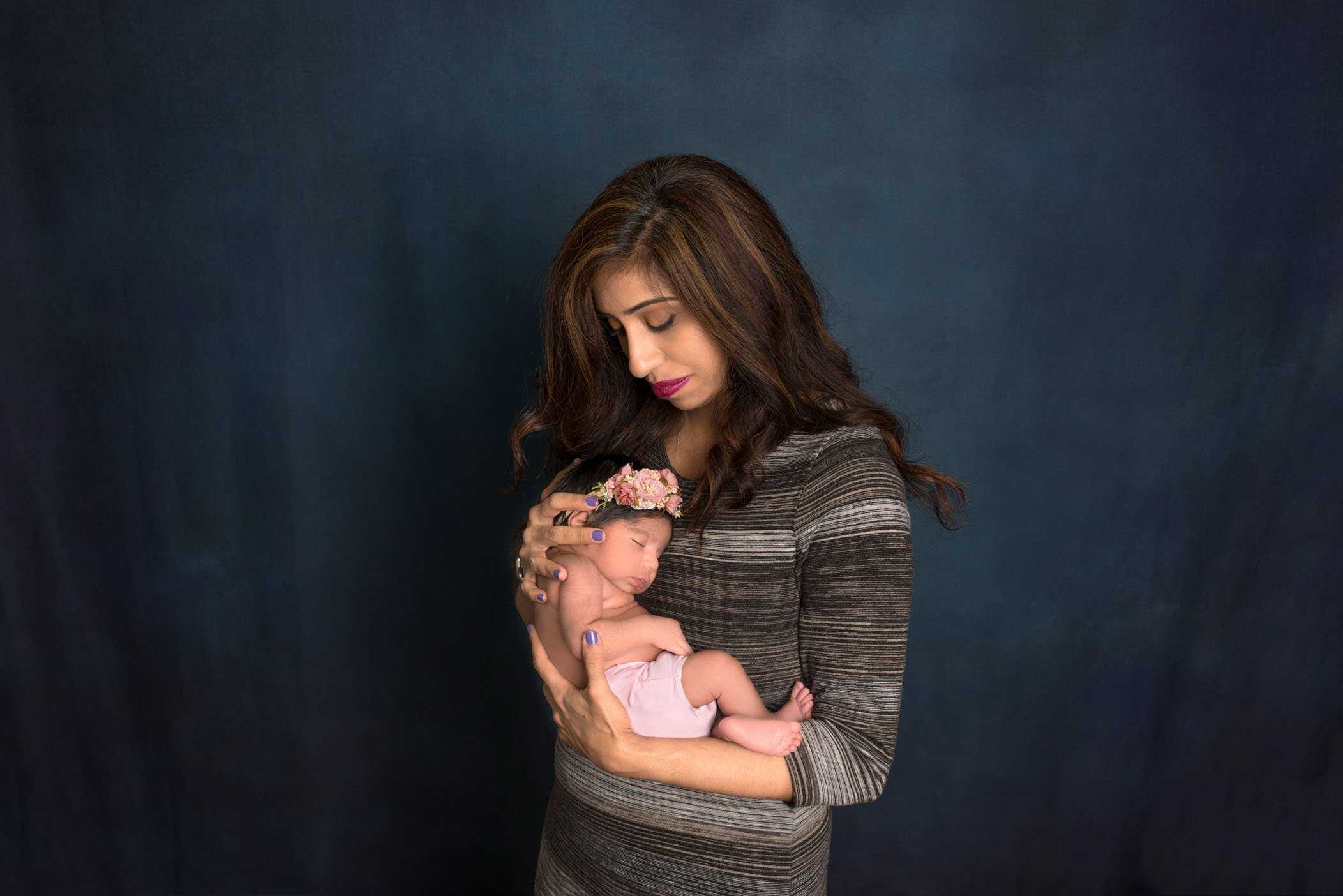 mom holding newborn baby close to her heart
