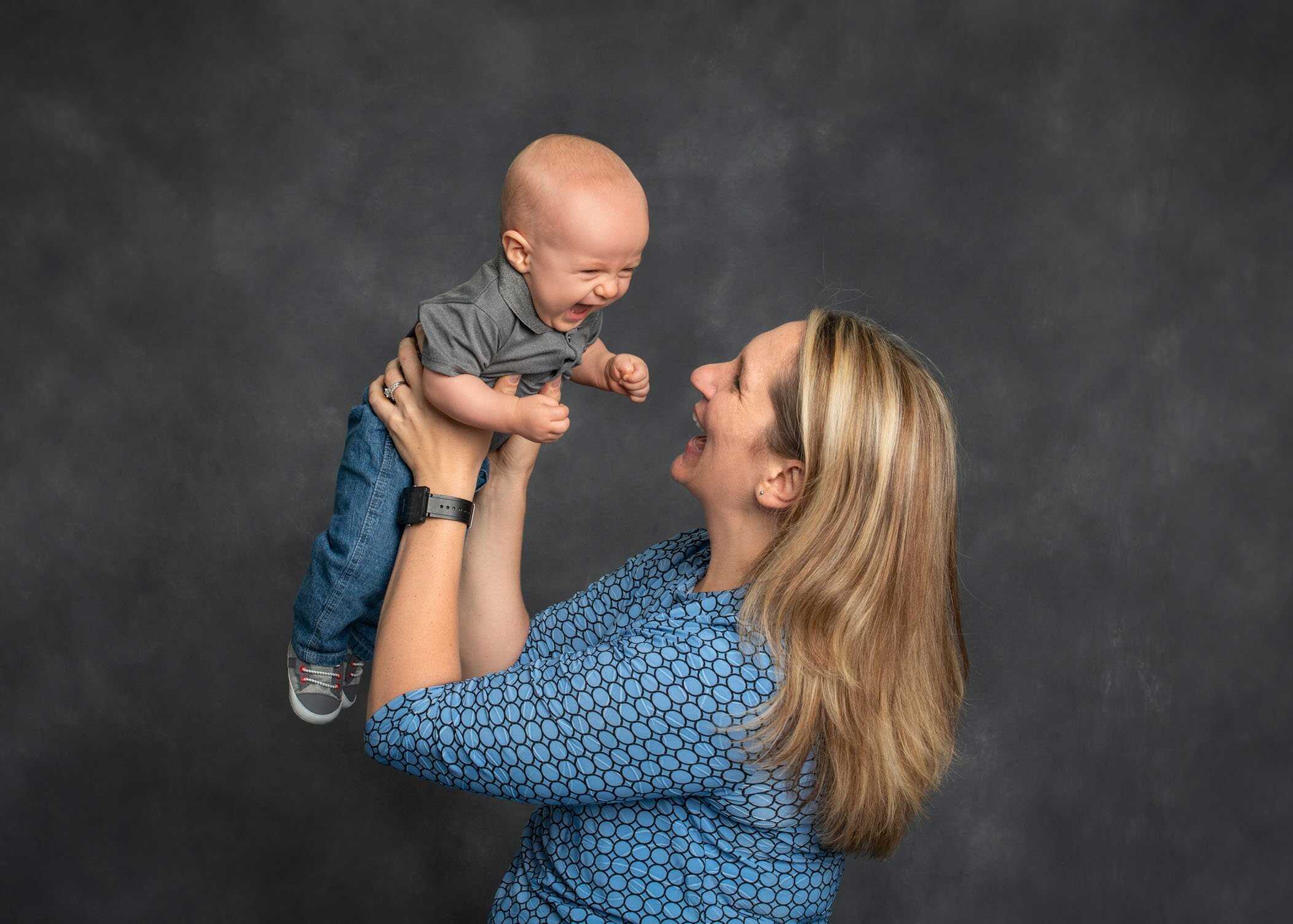 Mom flying her 6 month old baby boy in the air and laughing