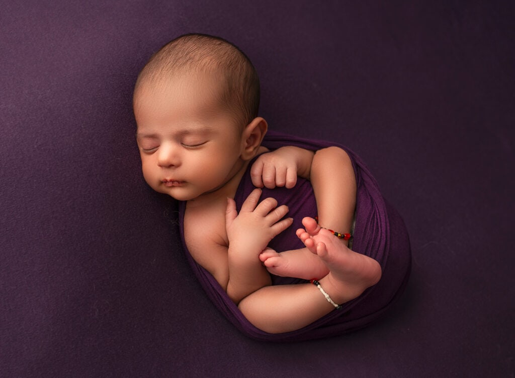 best newborn photograher best time to do newborn photos baby boy sleeping on purple blanket