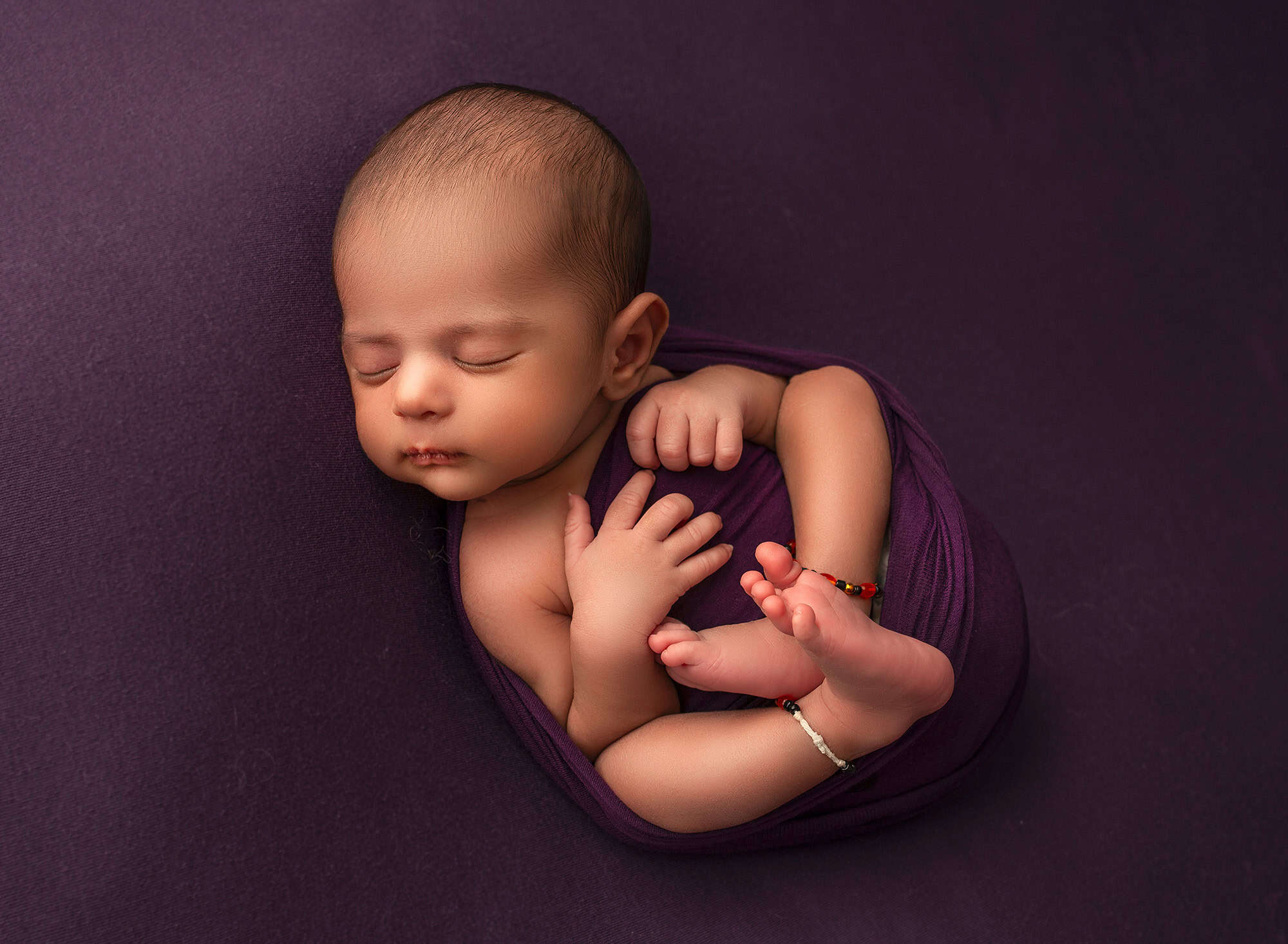 best newborn photograher best time to do newborn photos baby boy sleeping on purple blanket