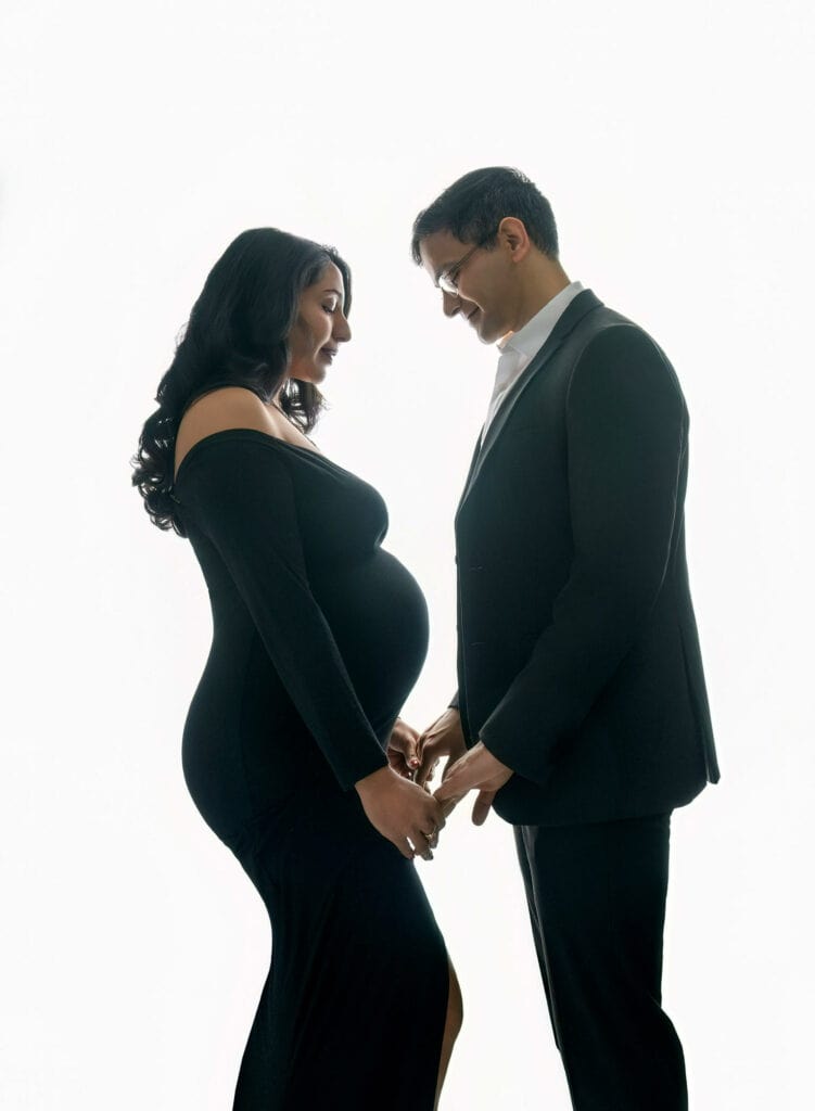 maternity photographer studio Elegant maternity portrait with mother in black gown and father in tuxedo.