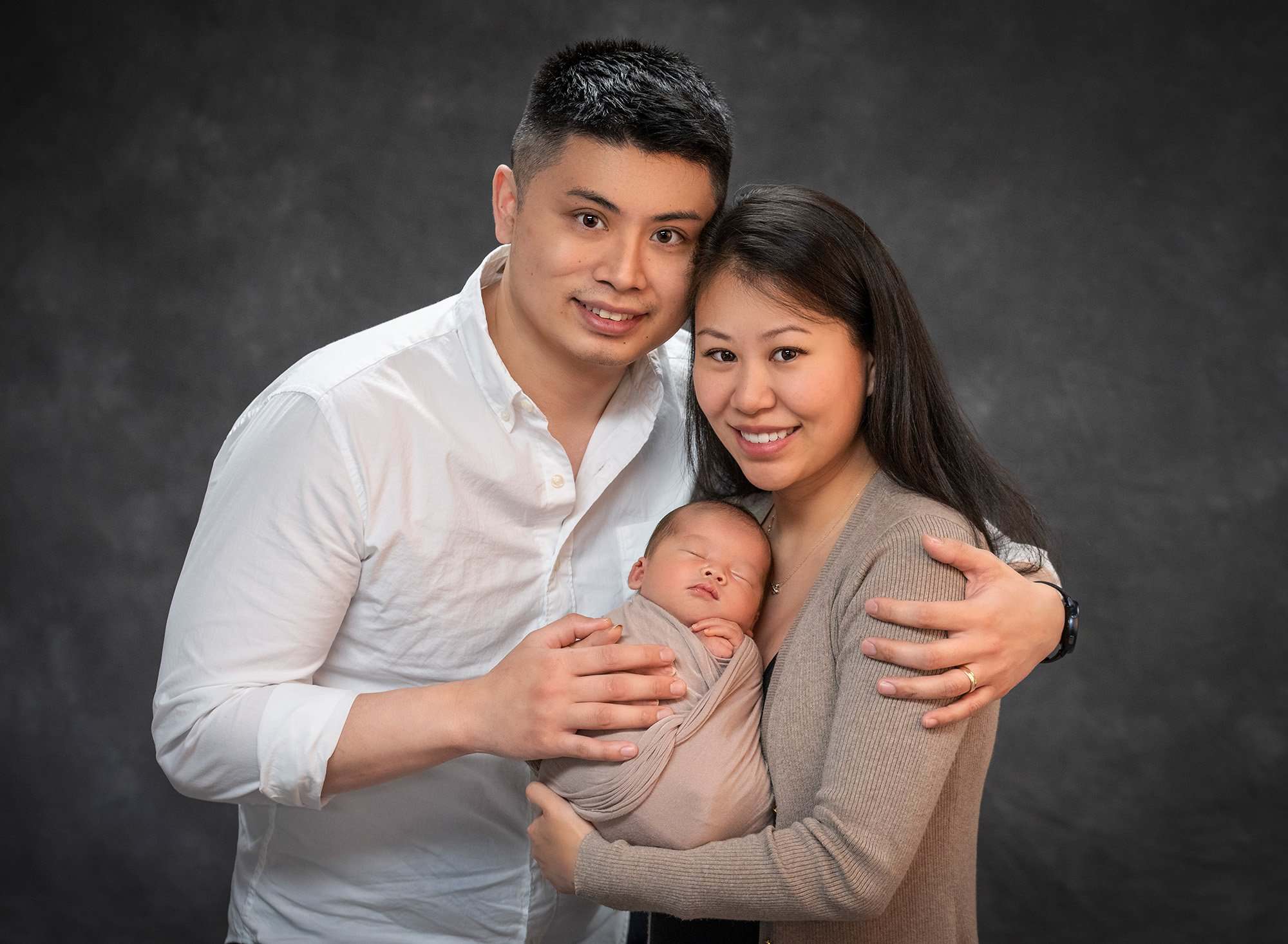 Baby Boy Newborn Photos new parents cradling asleep newborn baby boy swaddled in taupe