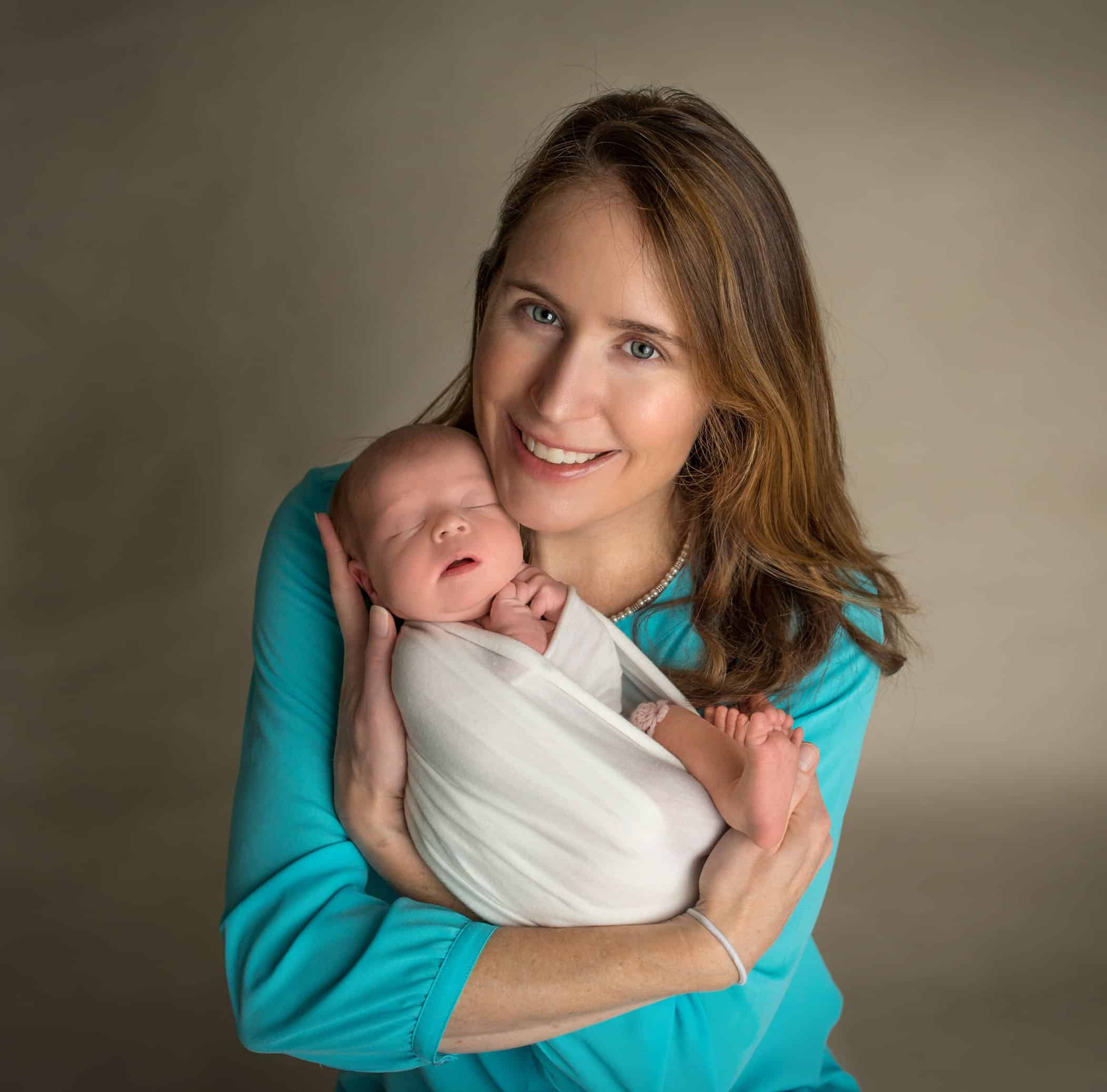Mom cradling newborn baby girl in her arms