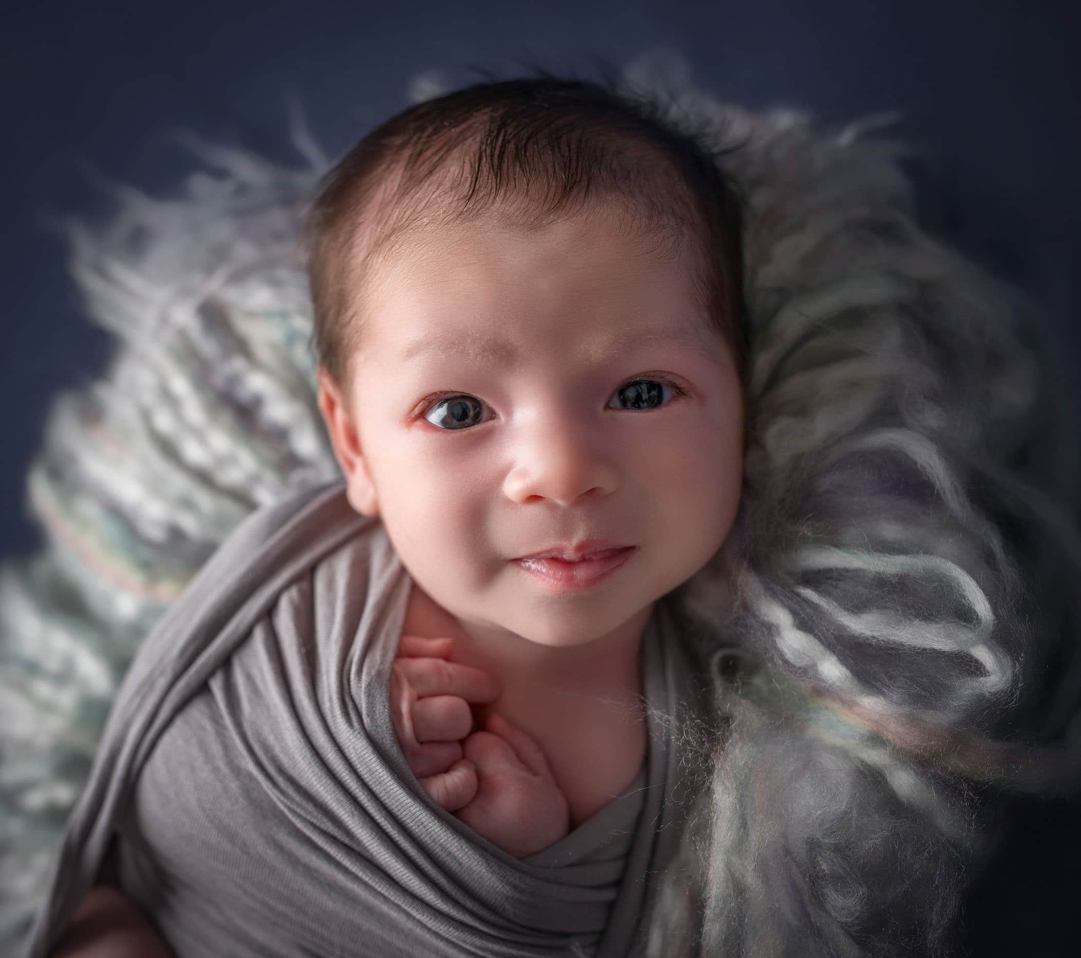 Newborn baby boy awake and looking at the camera