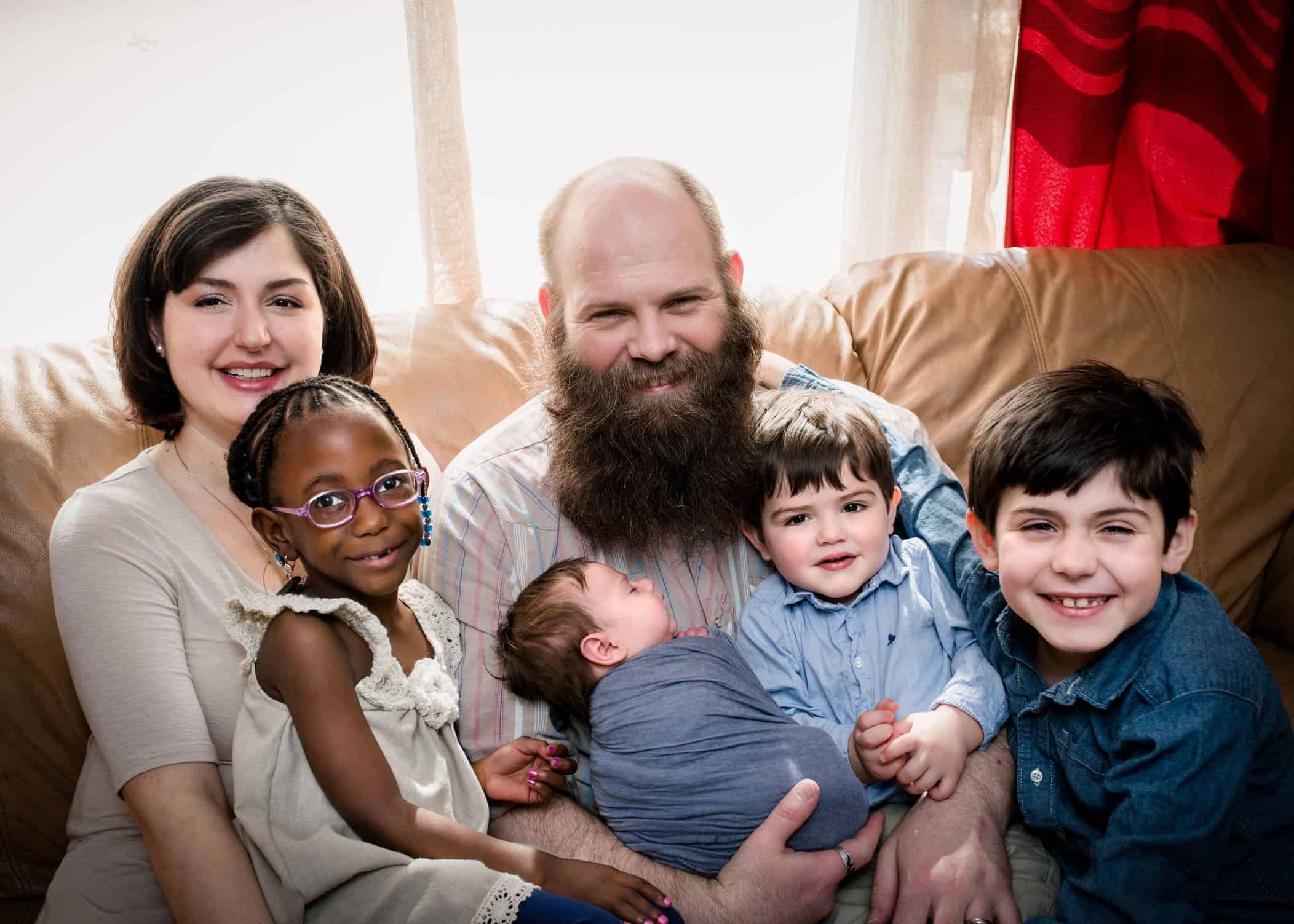 Family of six with newborn baby in the middle
