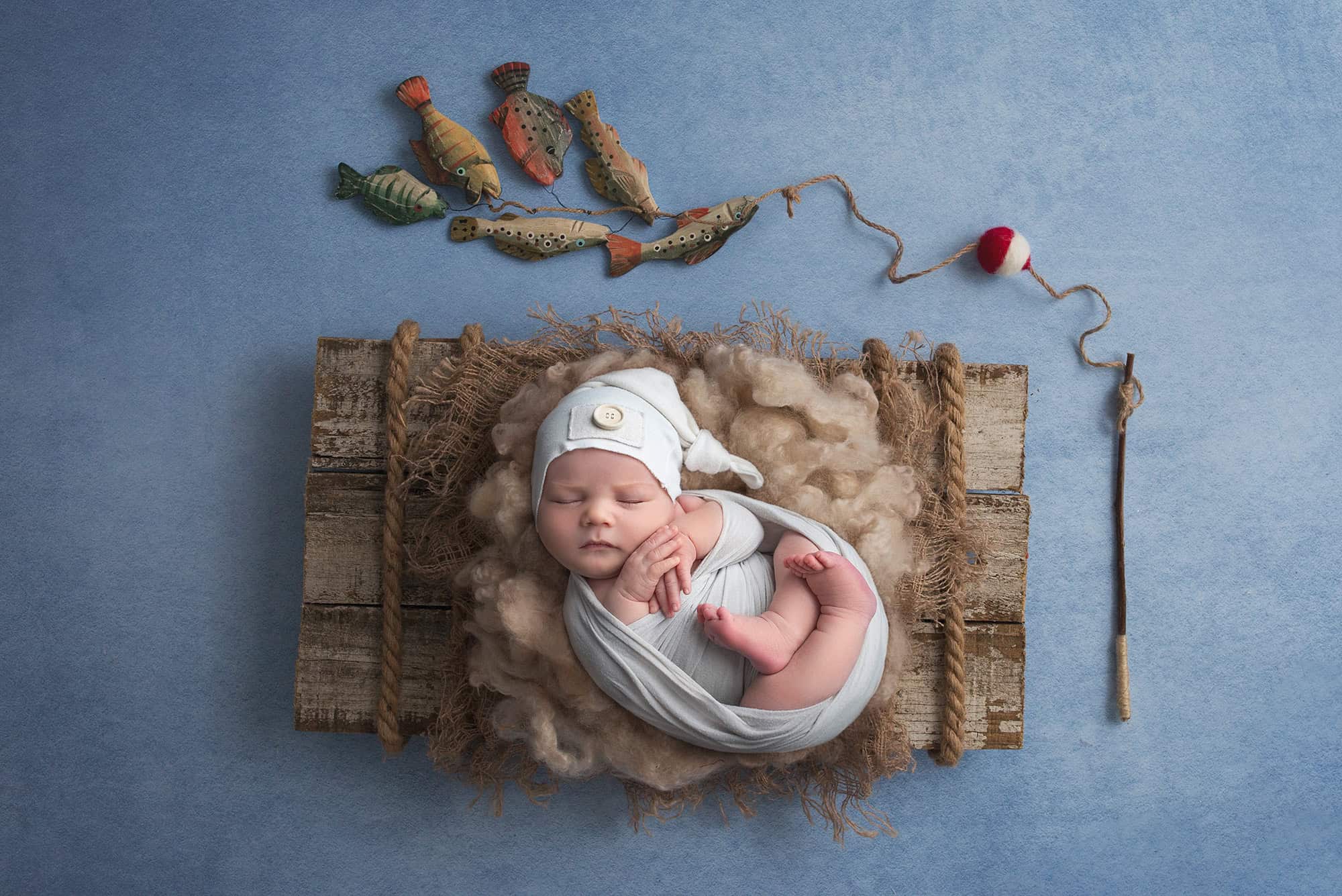 Nature Lover Newborn Photos newborn baby boy asleep on raft with fishing pole