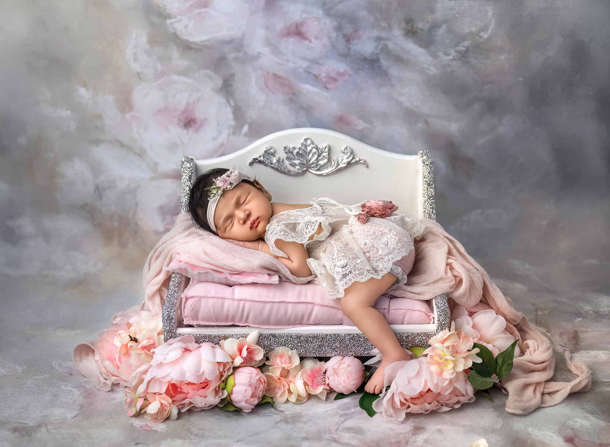 soft pastel newborn picture with peonies and tiny bed