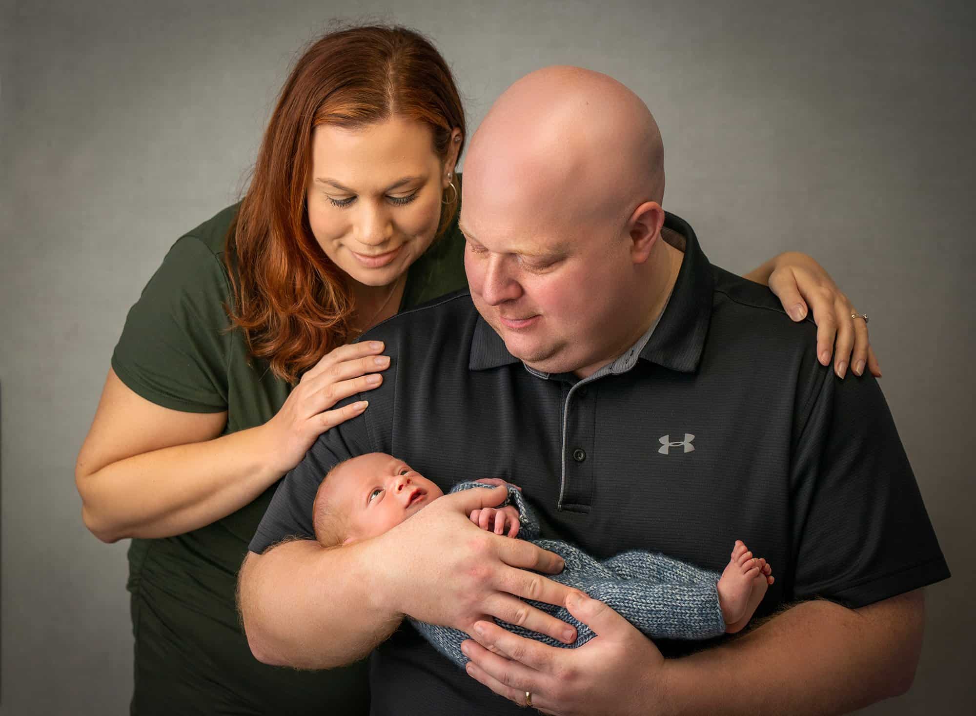 new parents looking down at their newborn baby son