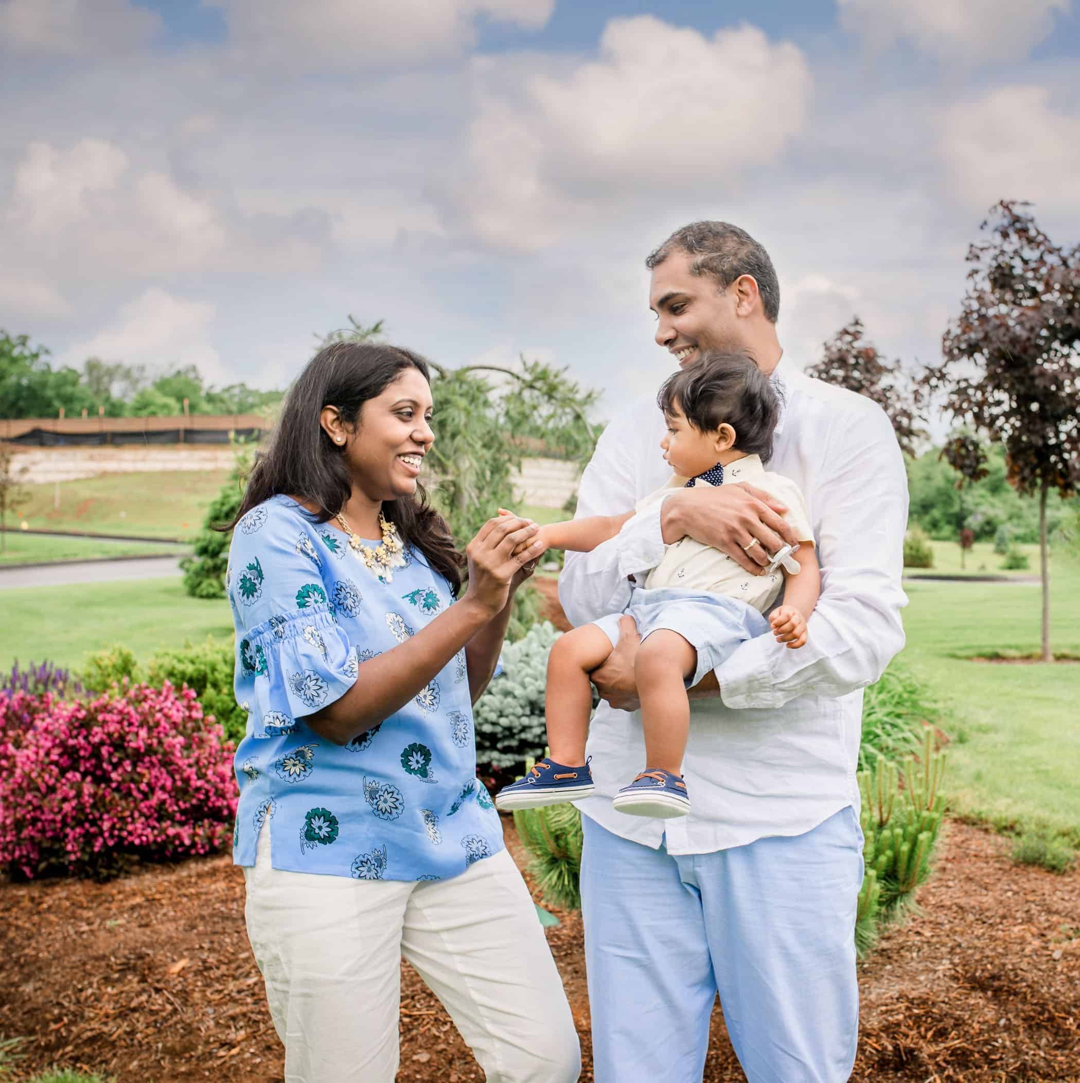 Mom and Dad playing with 8 mo old son in the garden