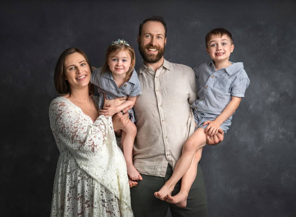 Family portrait with pregnant mom, dad, and two children—preparing siblings for newborn photos