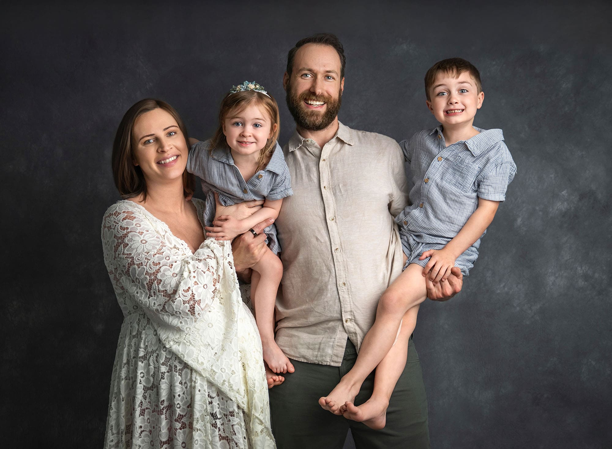 Family portrait with pregnant mom, dad, and two children—preparing siblings for newborn photos