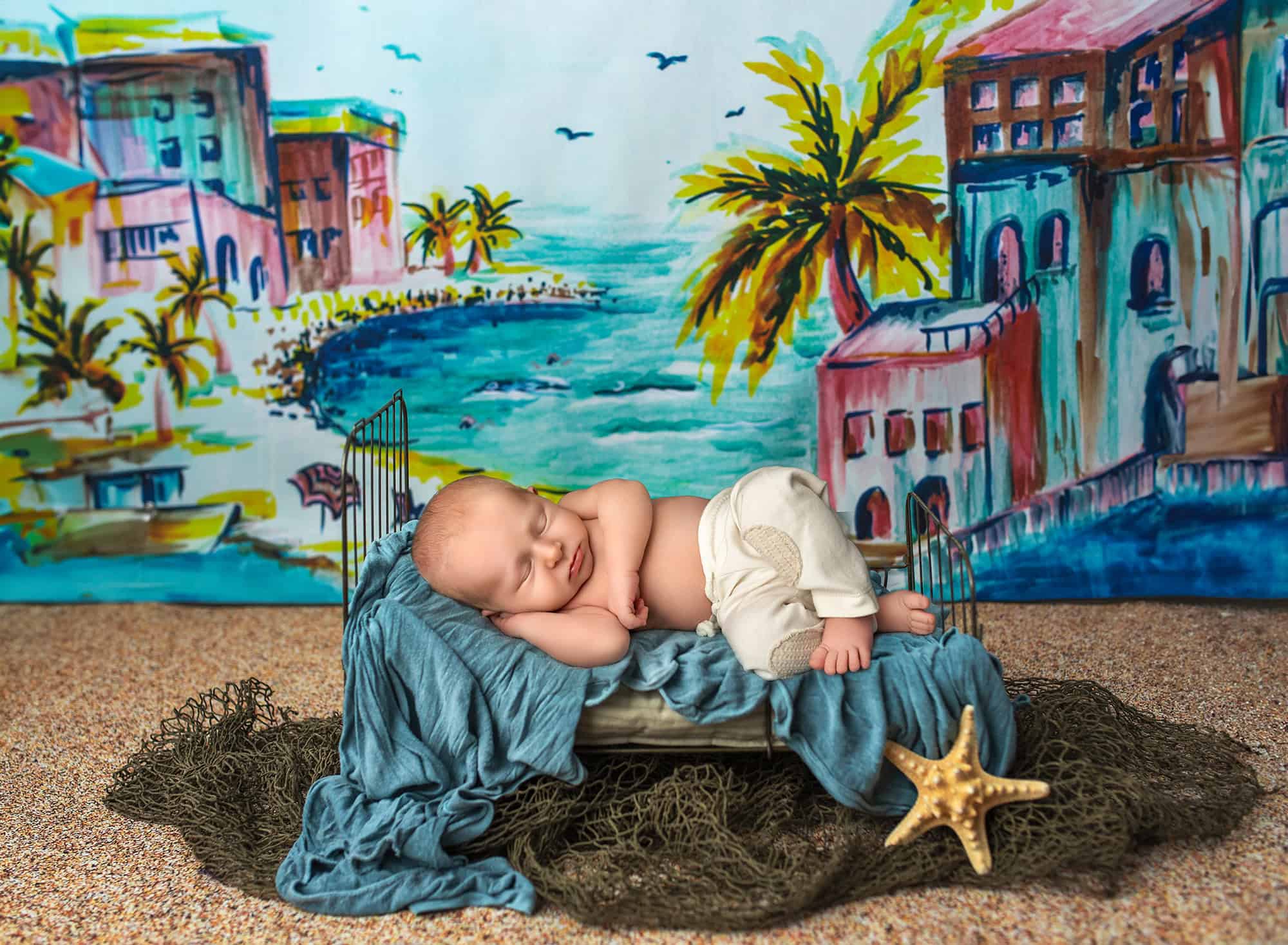 Creative baby photos Coastal-themed newborn photograph of Levi napping on a tiny bed with sea-blue textiles.