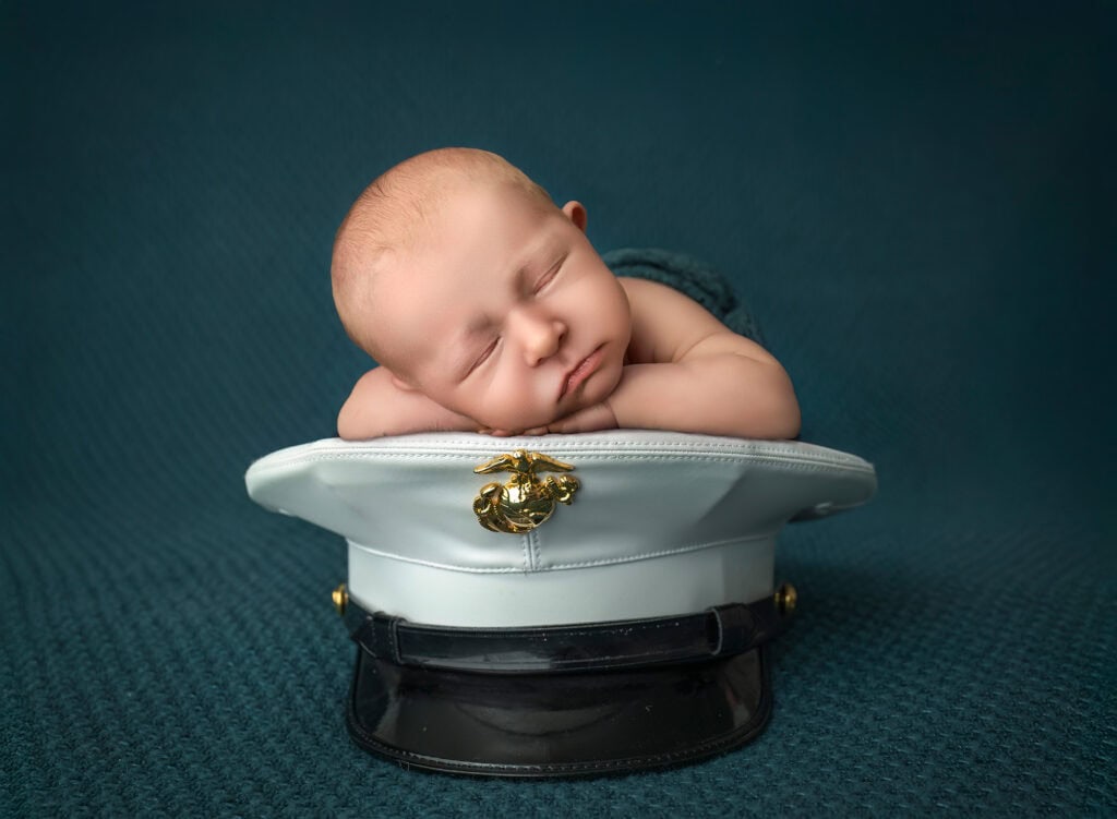 Marine Corps tribute portrait of sleeping Levi resting on Dad’s white cover with emblem.