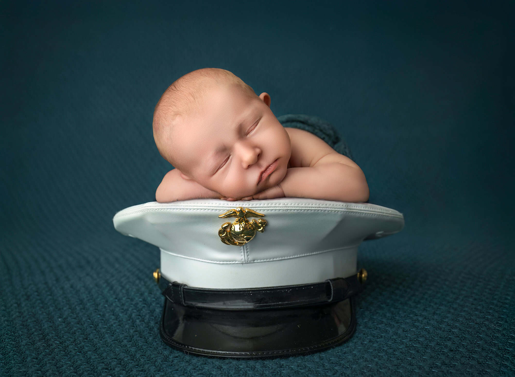 Marine Corps tribute portrait of sleeping Levi resting on Dad’s white cover with emblem.