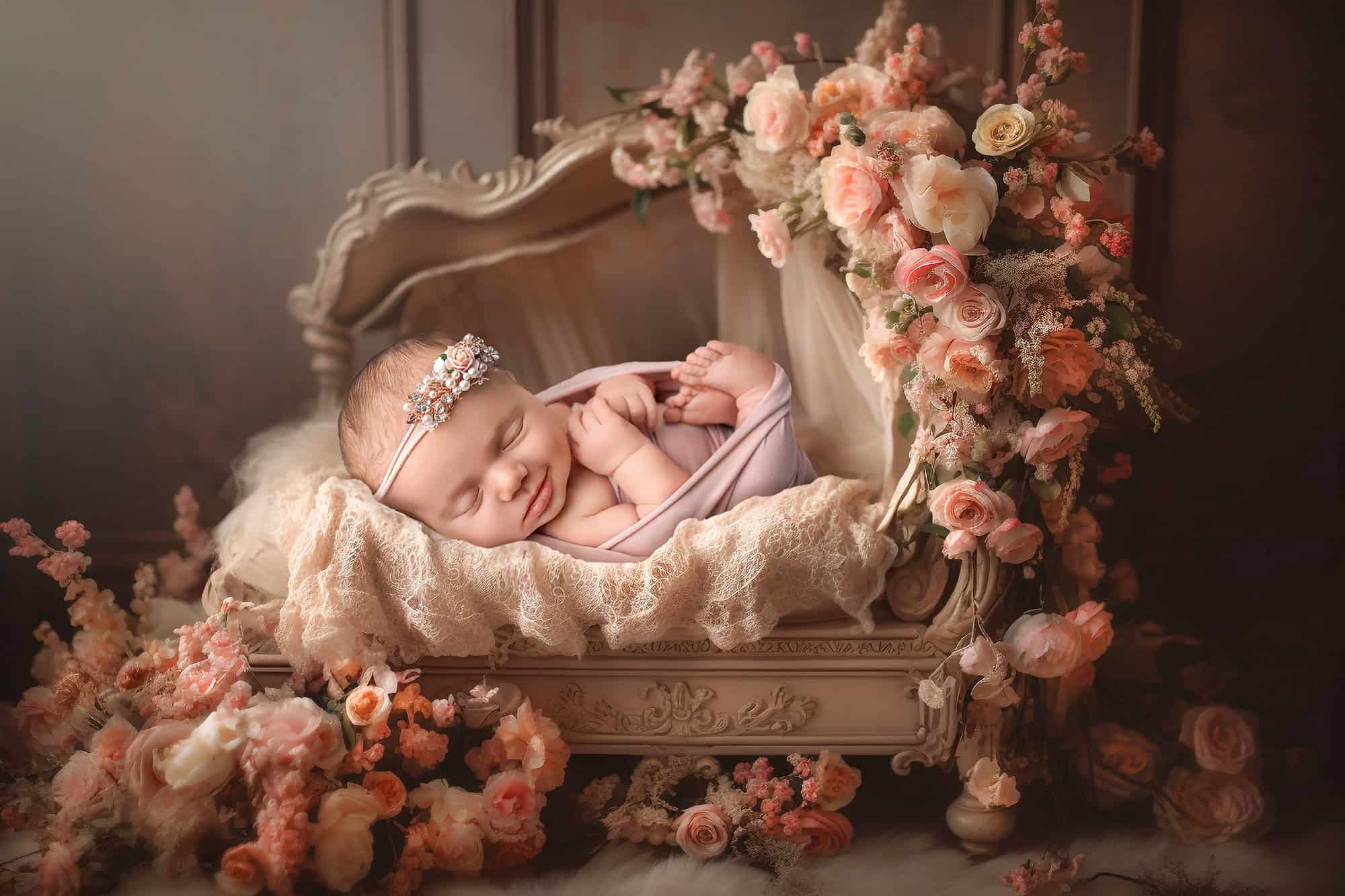 Connecticut newborn photographer Vintage bed with florals — Mia smiles in a fine art set with peach blooms.