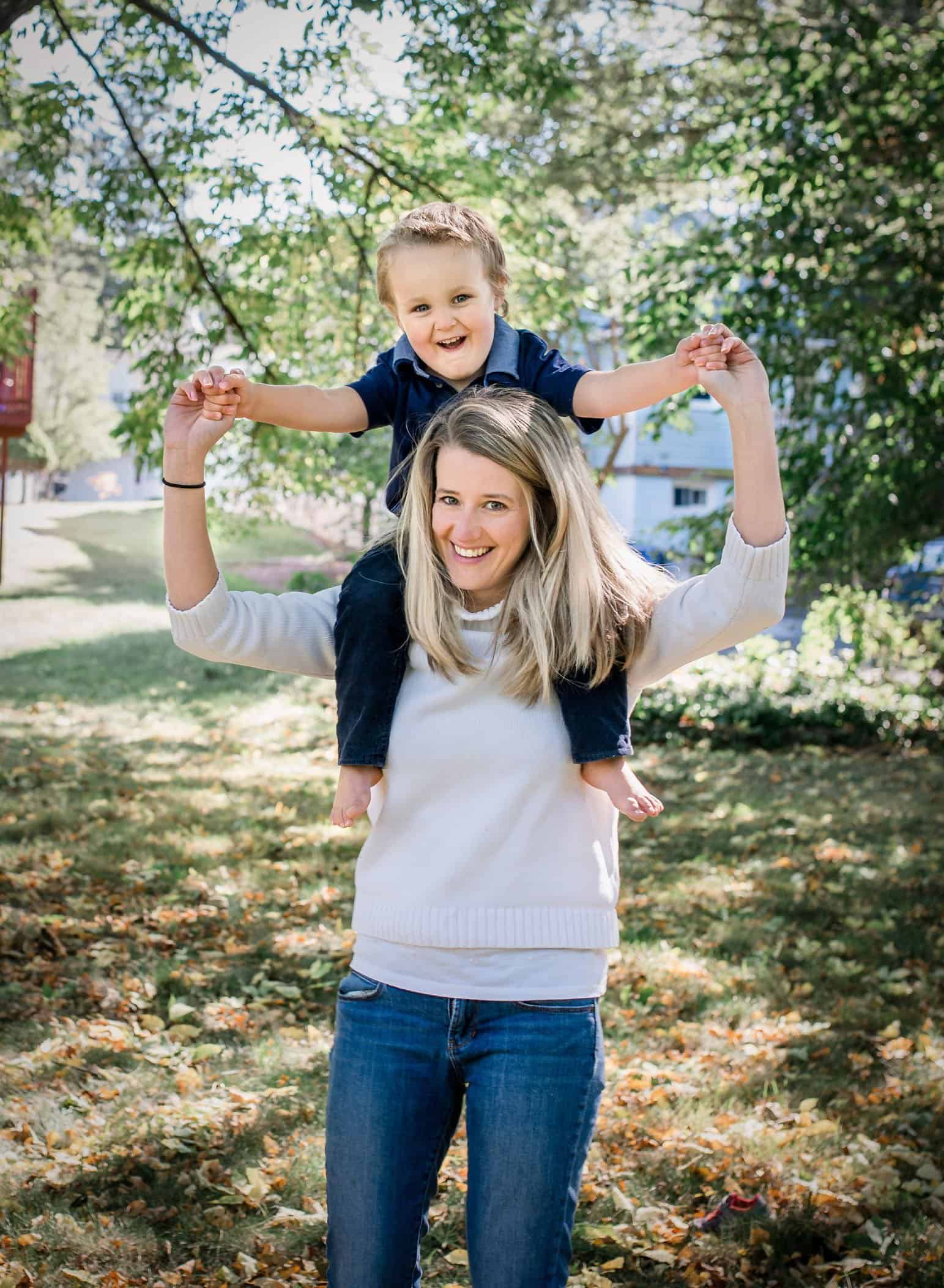 Mom with 4 year old son on her shoulders in the garden