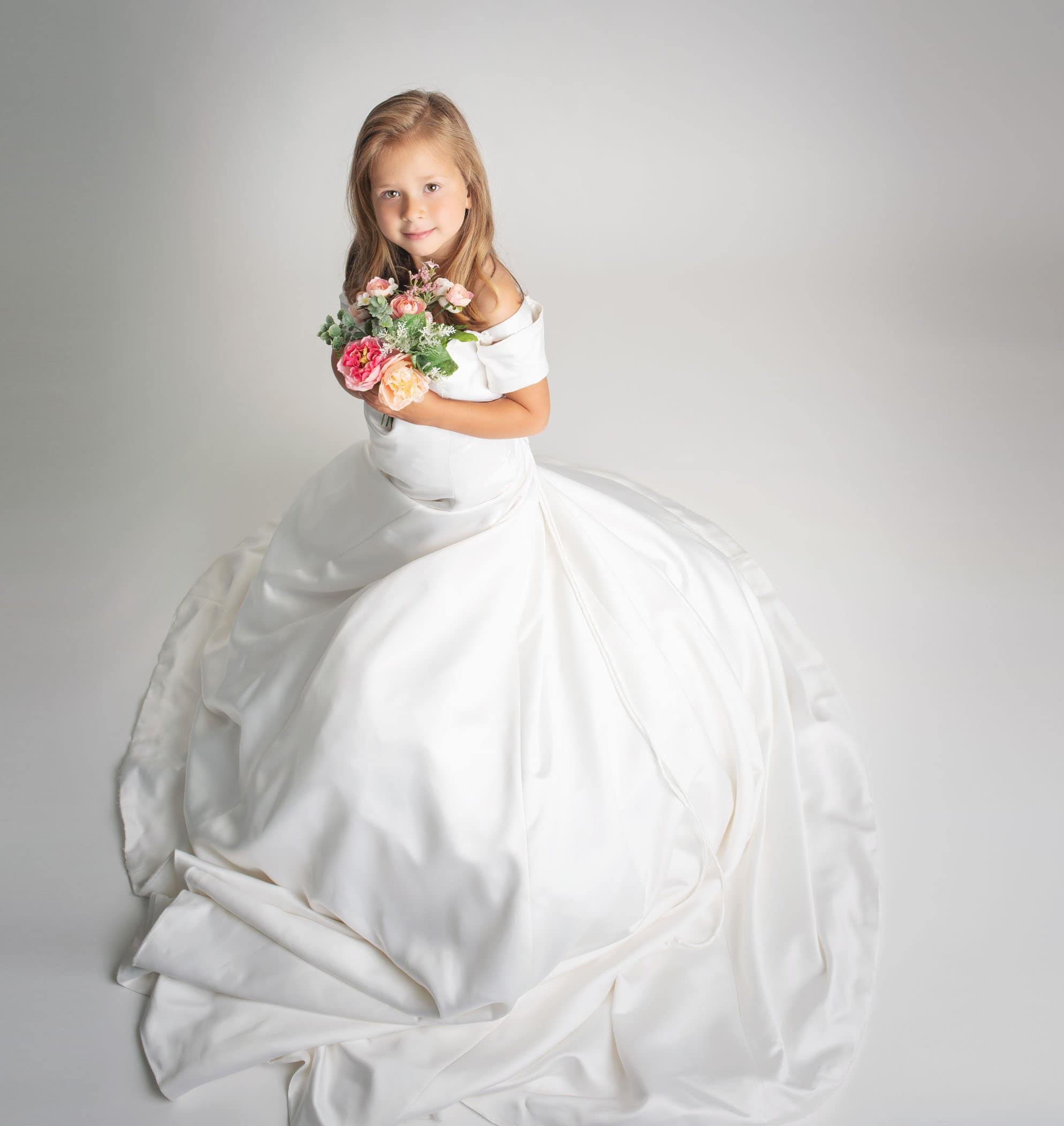 5 year old girl playing dress up in her mommy's wedding dress