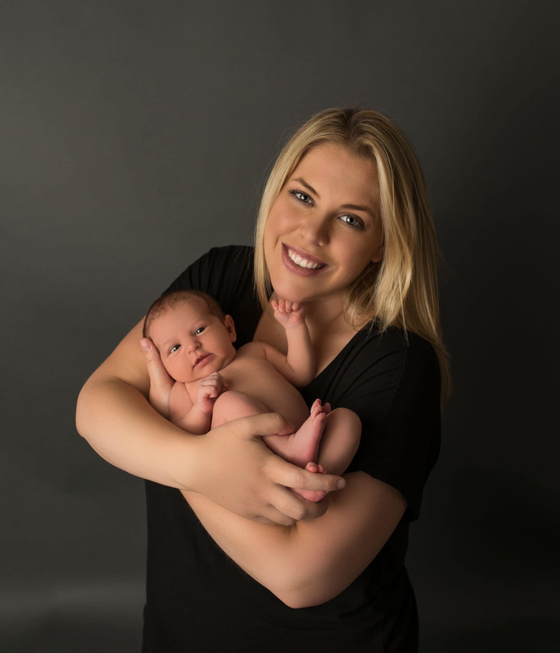 Mom holding her wide awake newborn daughter