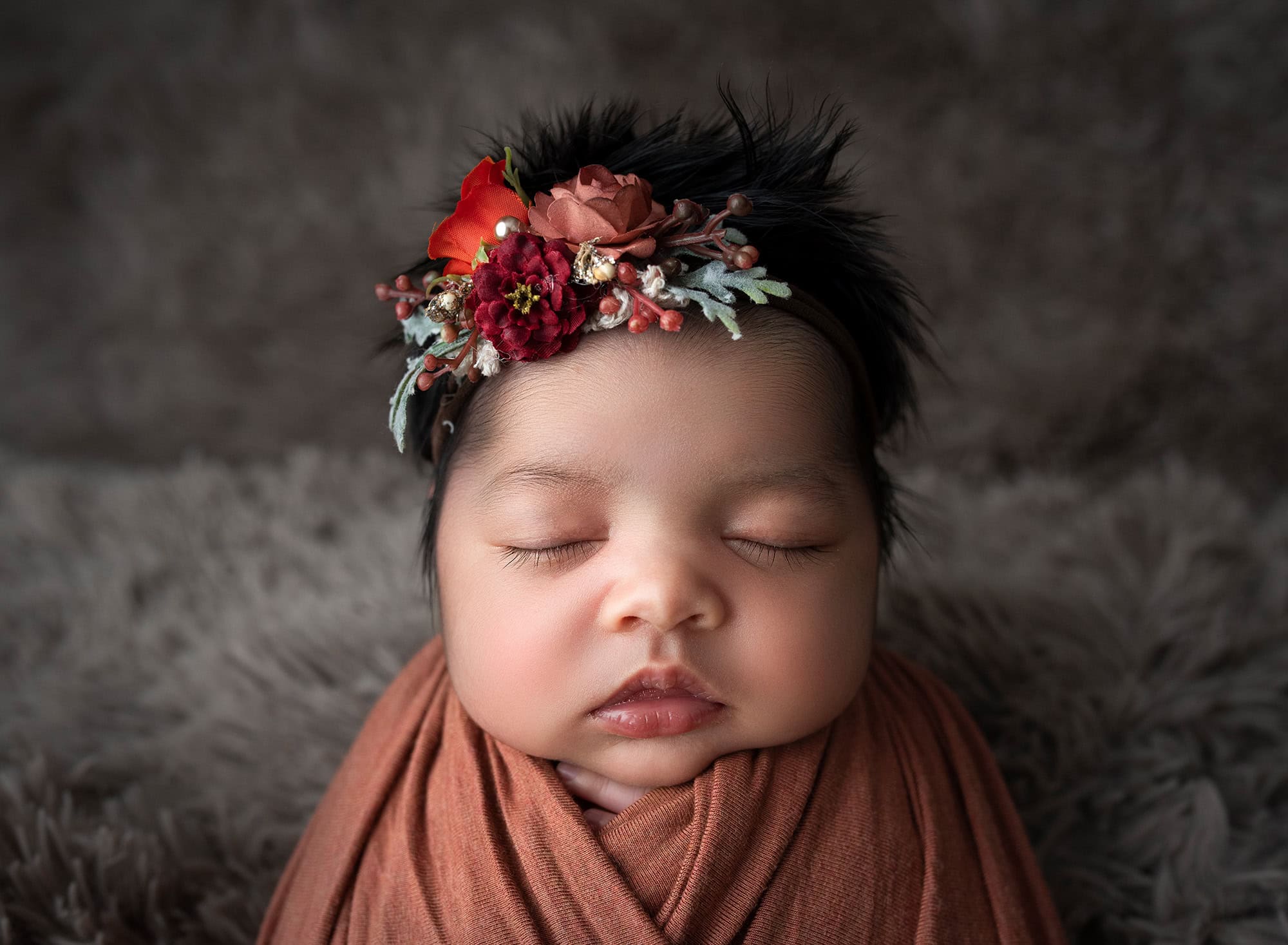newborn baby girl swaddled in rustic orange wearing fall themed headband