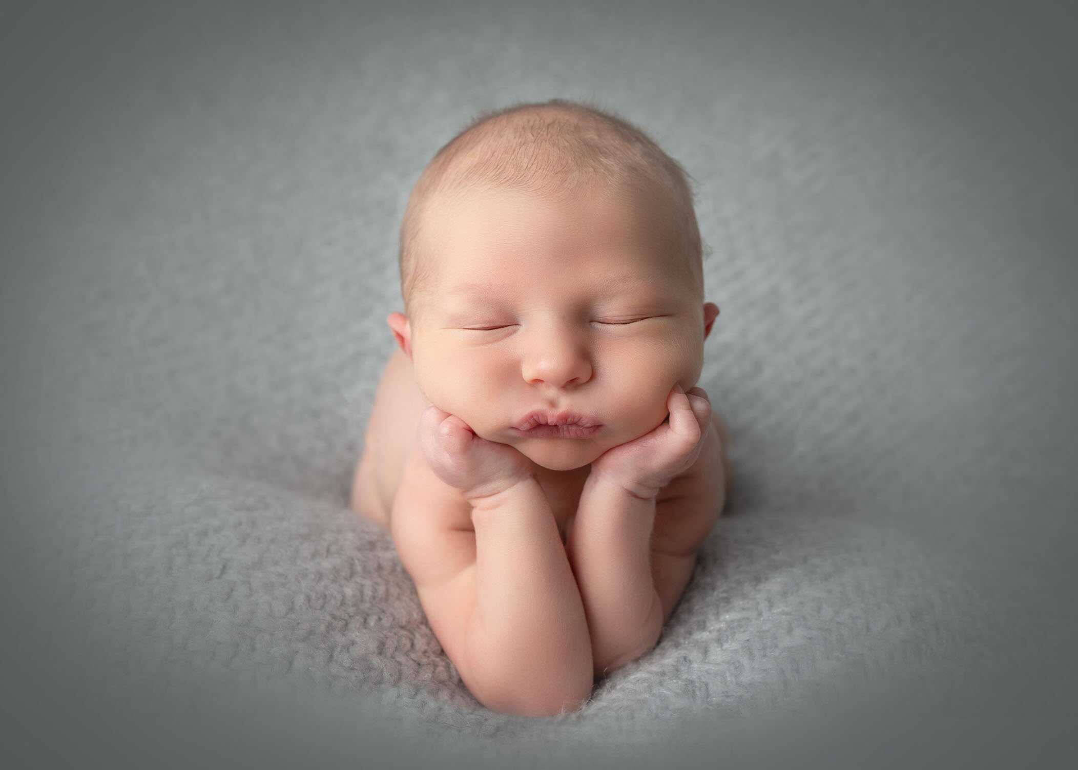 newborn boy on grey blanket in froggy position