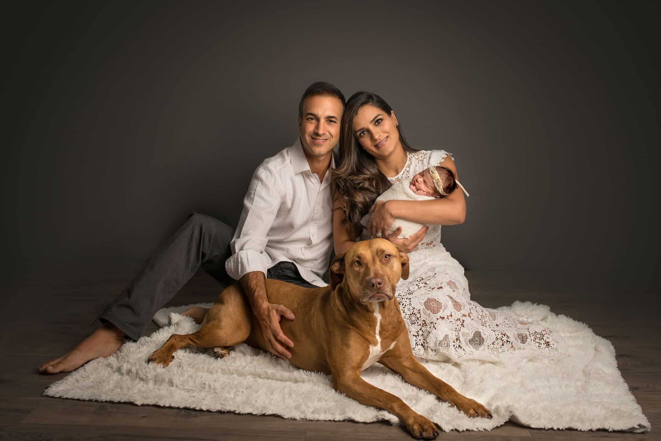 Mom Dad newborn baby with family dog