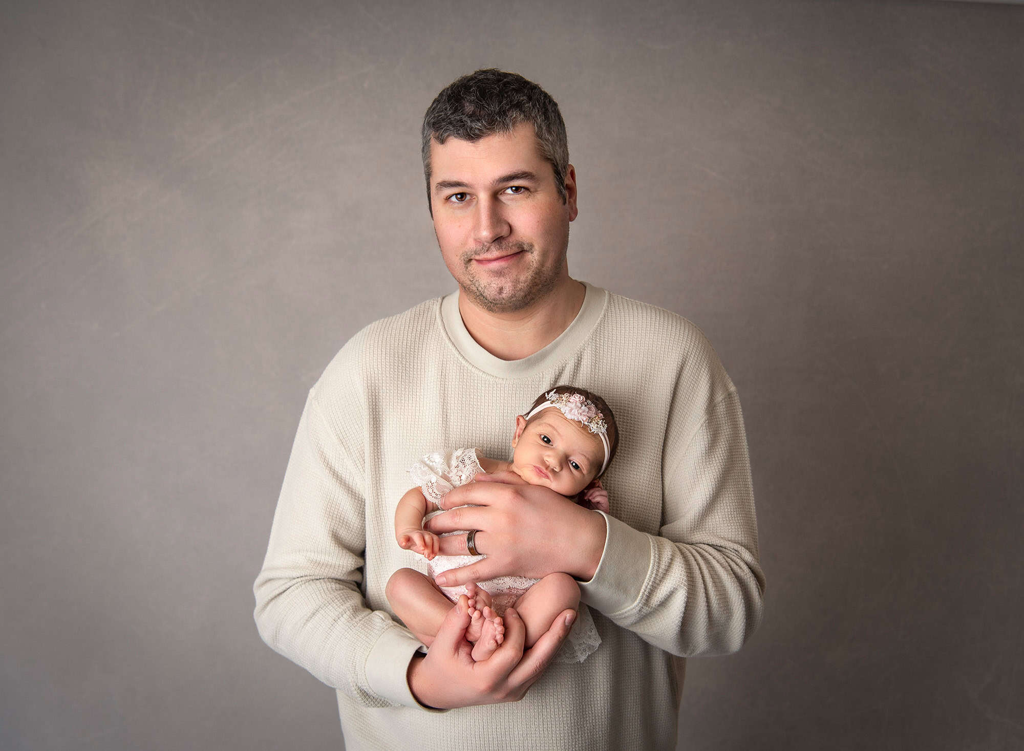 dad posing with newborn baby girl wearing lace dress