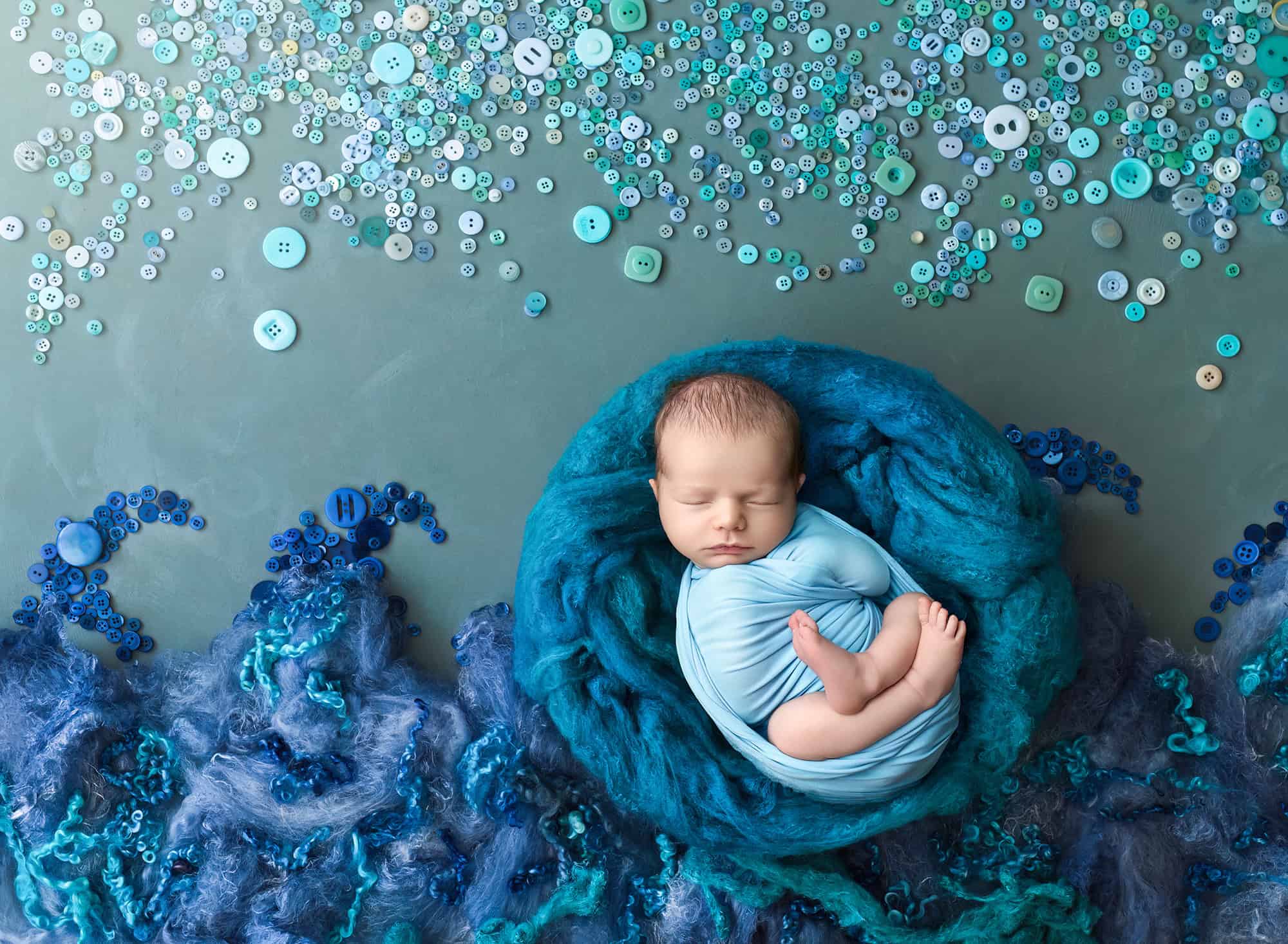 Leif sleeping in aqua nest with button ‘ocean’ creative set