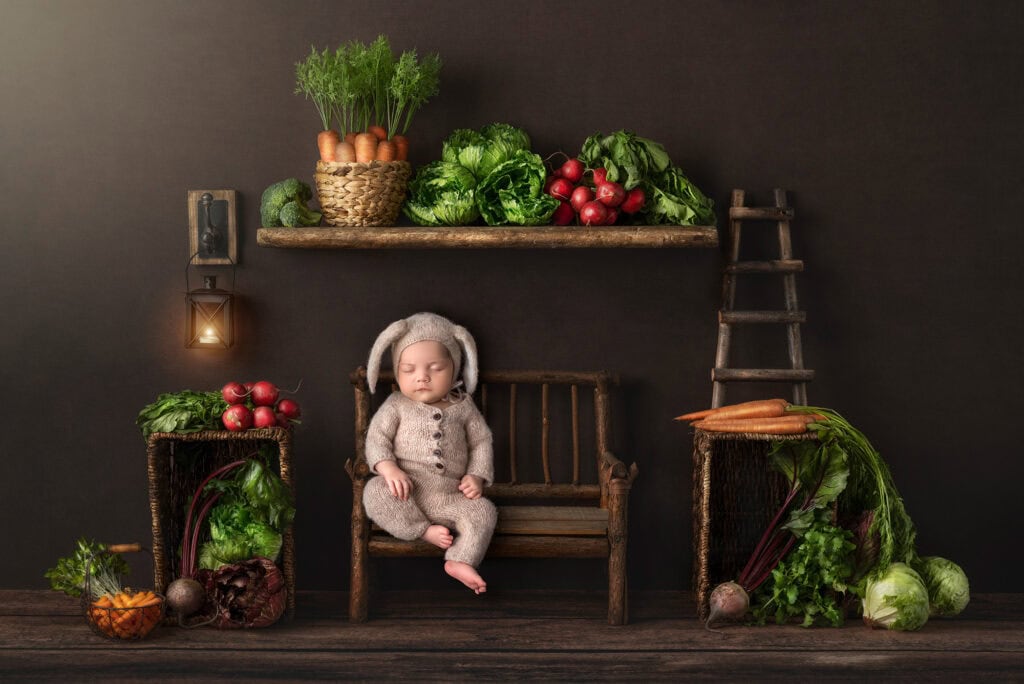 best newborn photographer best time for a newborn shoot baby dressed as a bunny with fresh vegetables all around