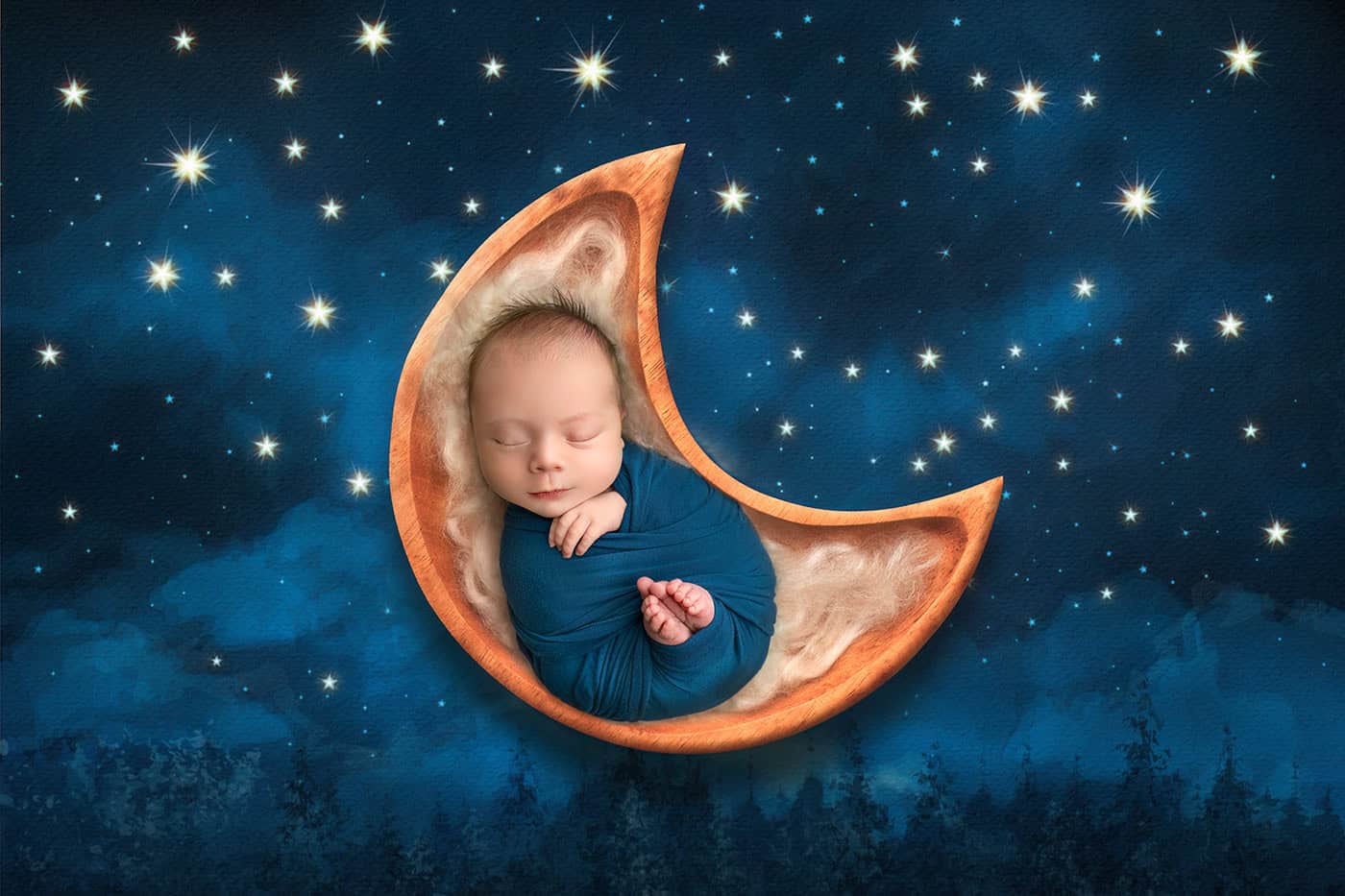 newborn boy photos sleeping in a wooden bowl the shape of the moon on a star filled background